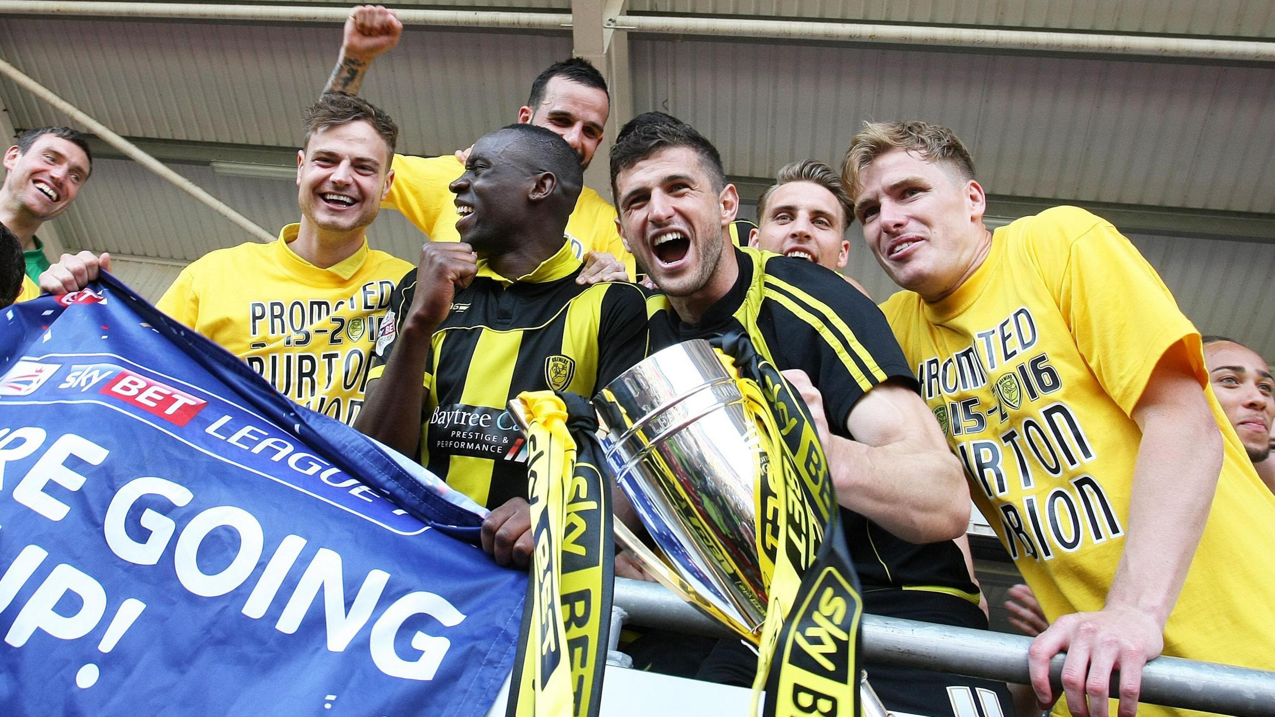 Burton Albion players, including now Portsmouth manager John Mousinho, celebrate promotion to the Championship in 2016