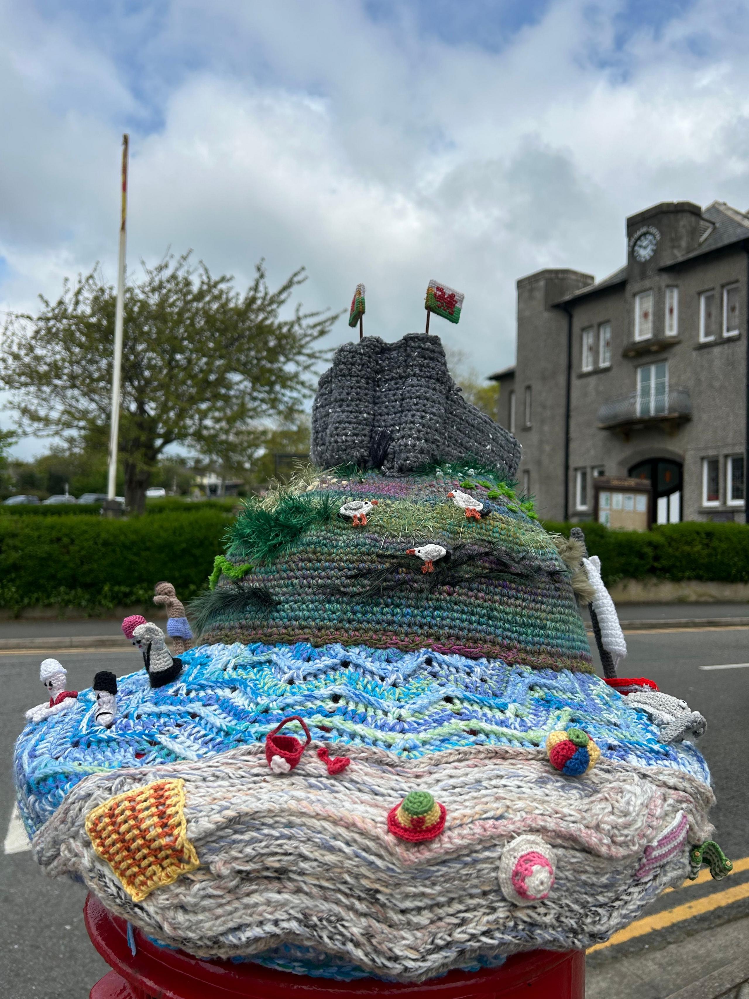 Castell Cricieth a'r traeth ar ben un blwch post yn y dref