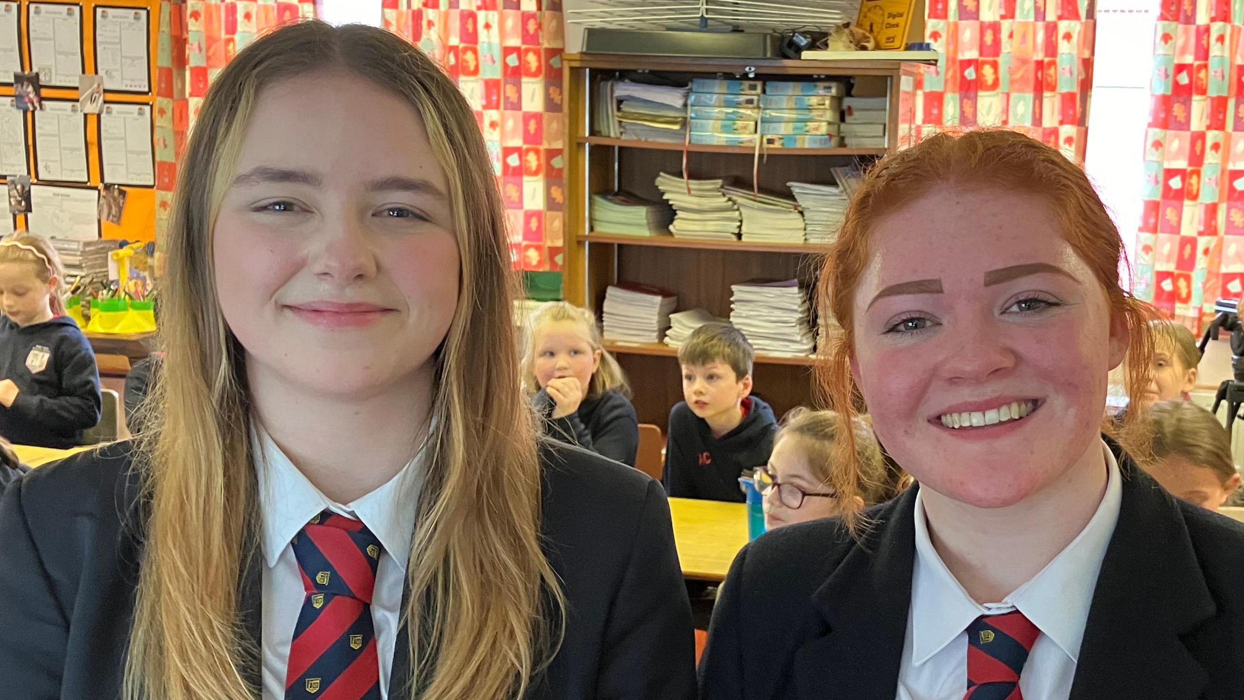 Students smiling into the camera in a classroom setting