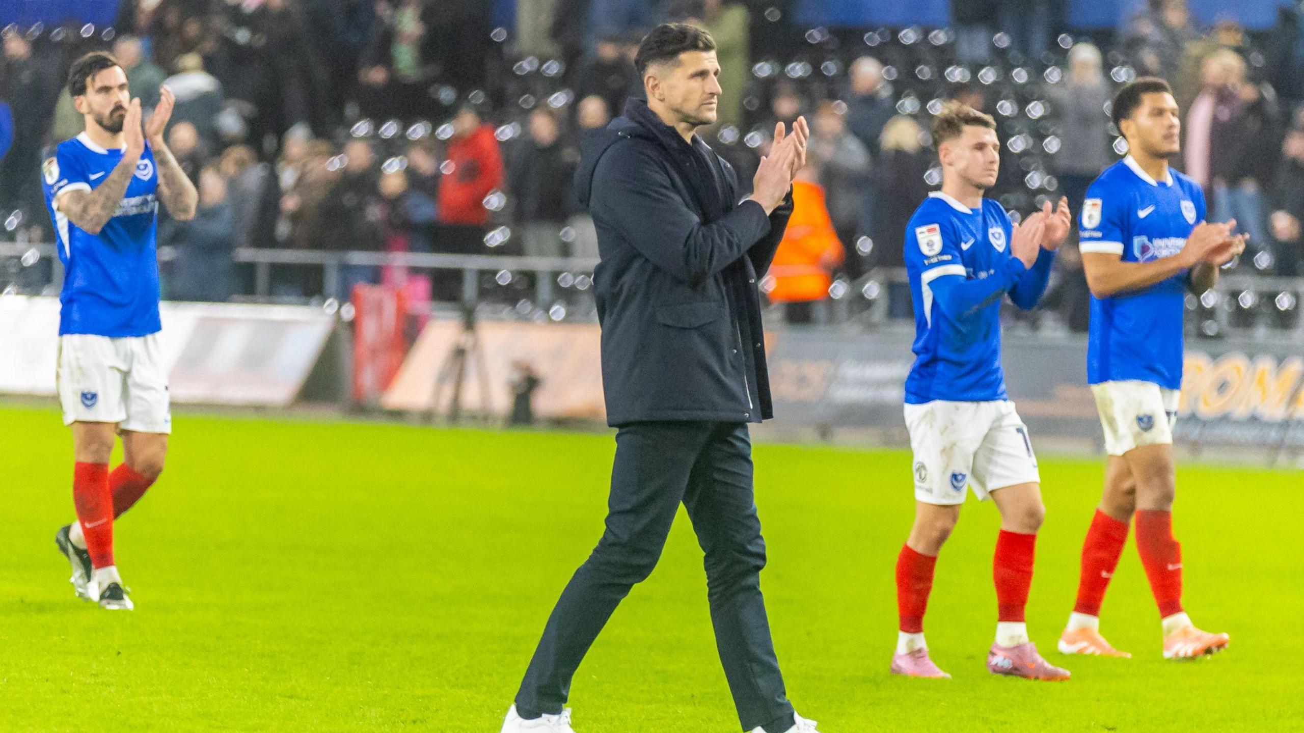 Portsmouth boss John Mousinho and his players applauding their fans after their loss to Swansea City