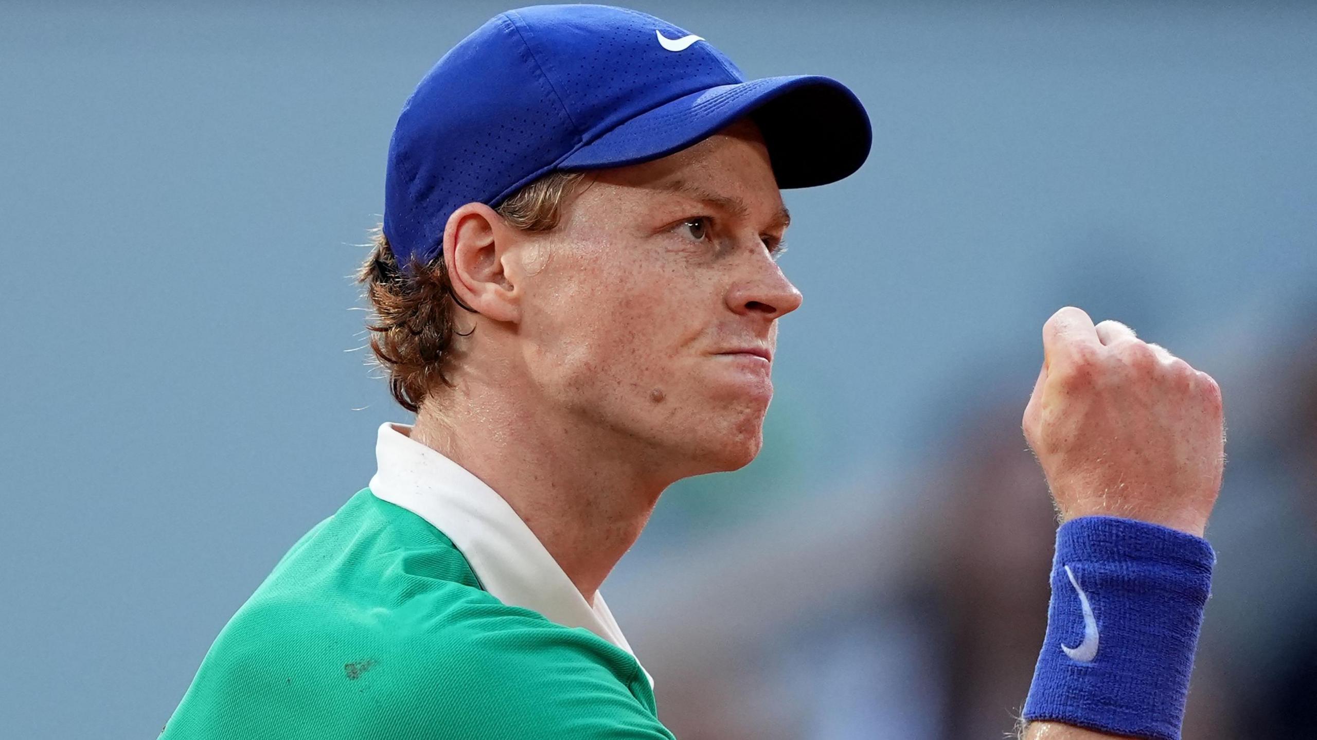 Jannik Sinner clenches his fist in celebration during his French Open match against Novak Djokovic