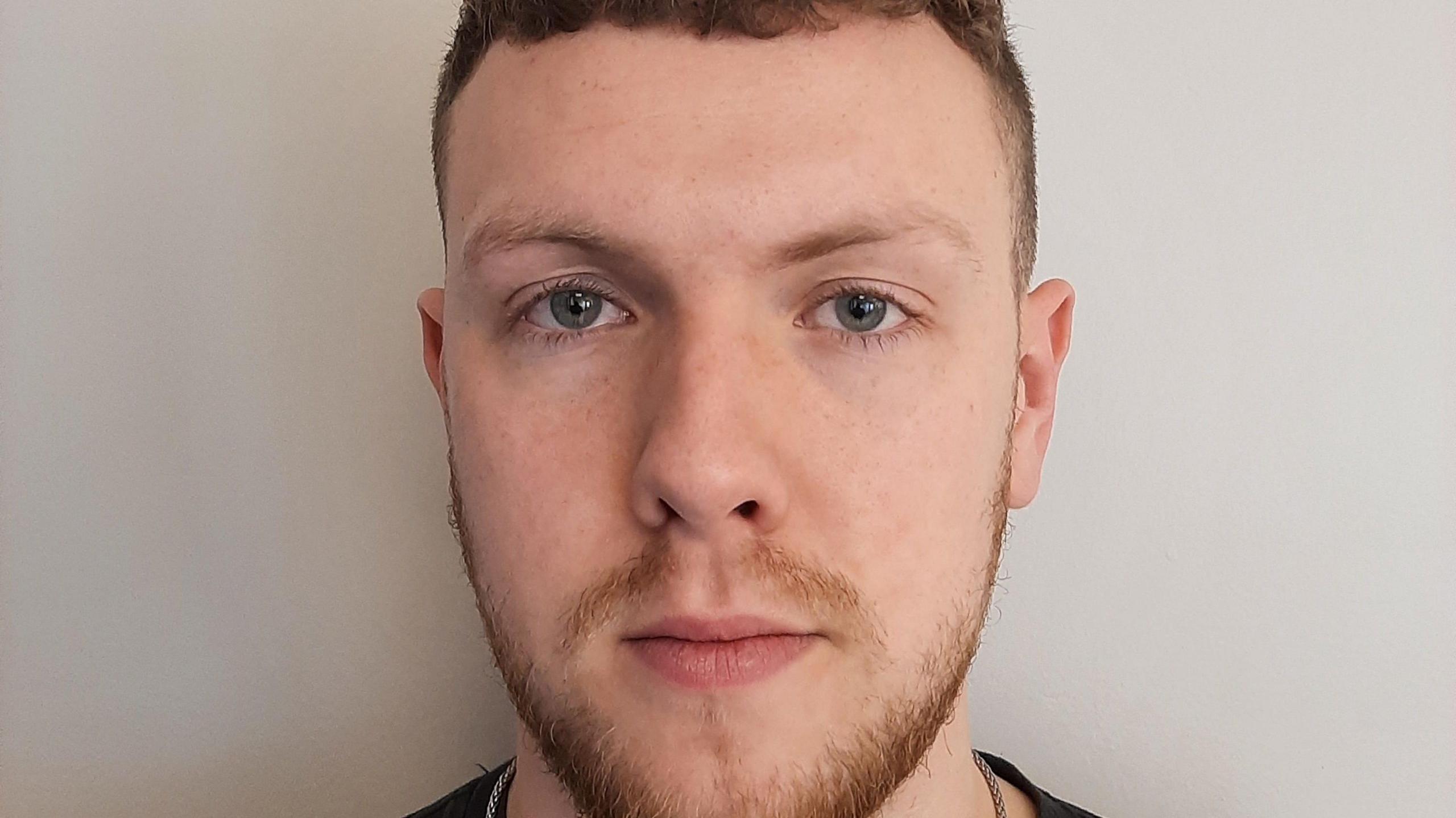 Custody picture of Benjamin Bottomley, a young man with a short beard.