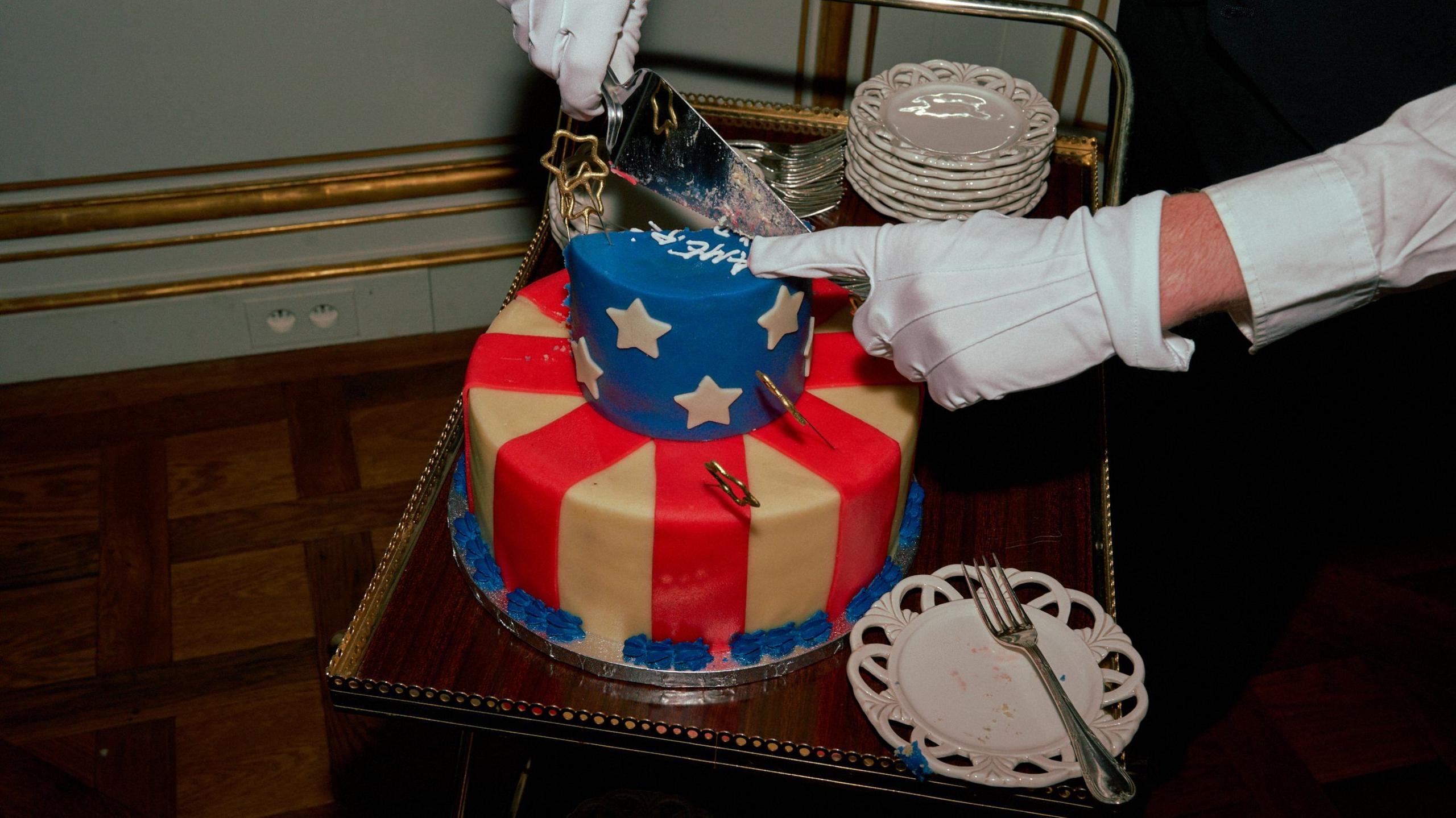 American flag cake being cut into by waiter