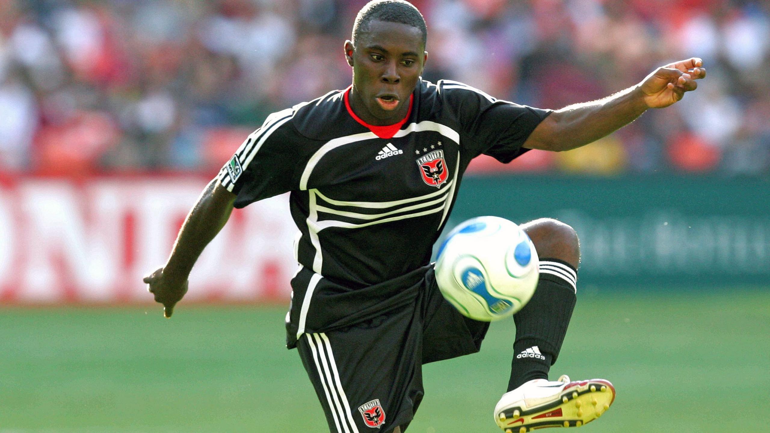 Freddy Adu playing for DC United, in an all black kit, against New York Red Bulls in 2006. 