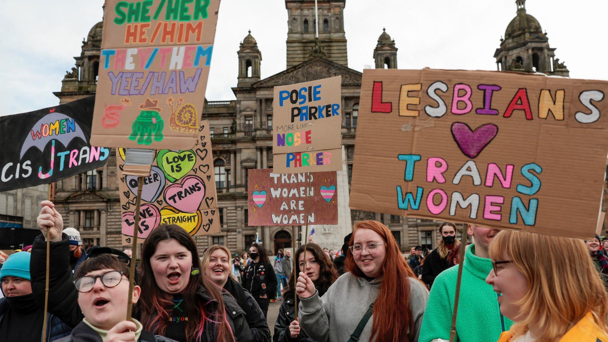 Pro trans rights protestors hold placards in Glasgow's George Square 