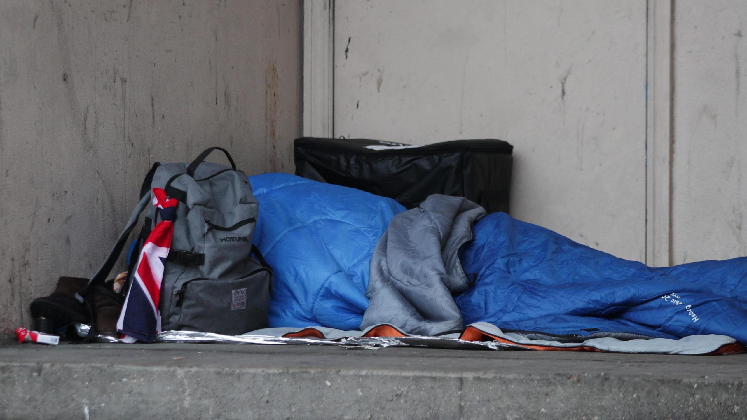 Rough sleeper in a sleeping bag in a doorway