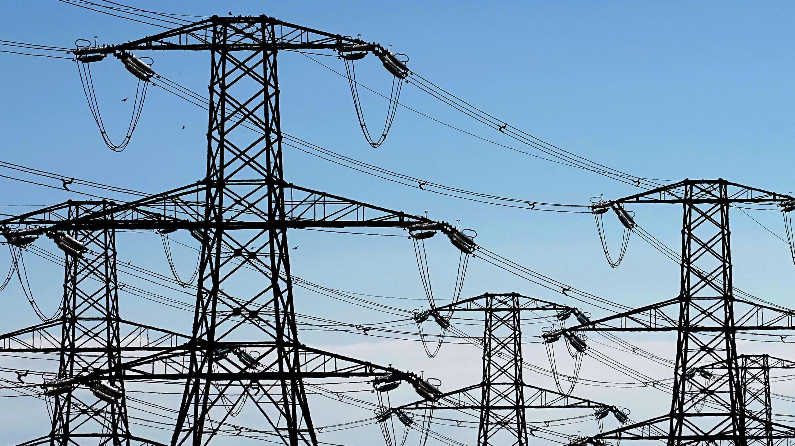 Five pylons against a blue sky.
