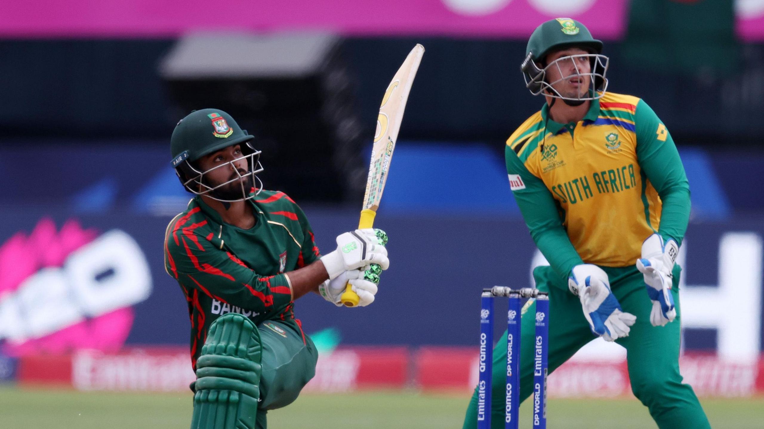 Bangladesh's Towhid Hridoy hits out, watched by South Africa wicketkeeper Quinton de Kock, in a T20 international in 2024