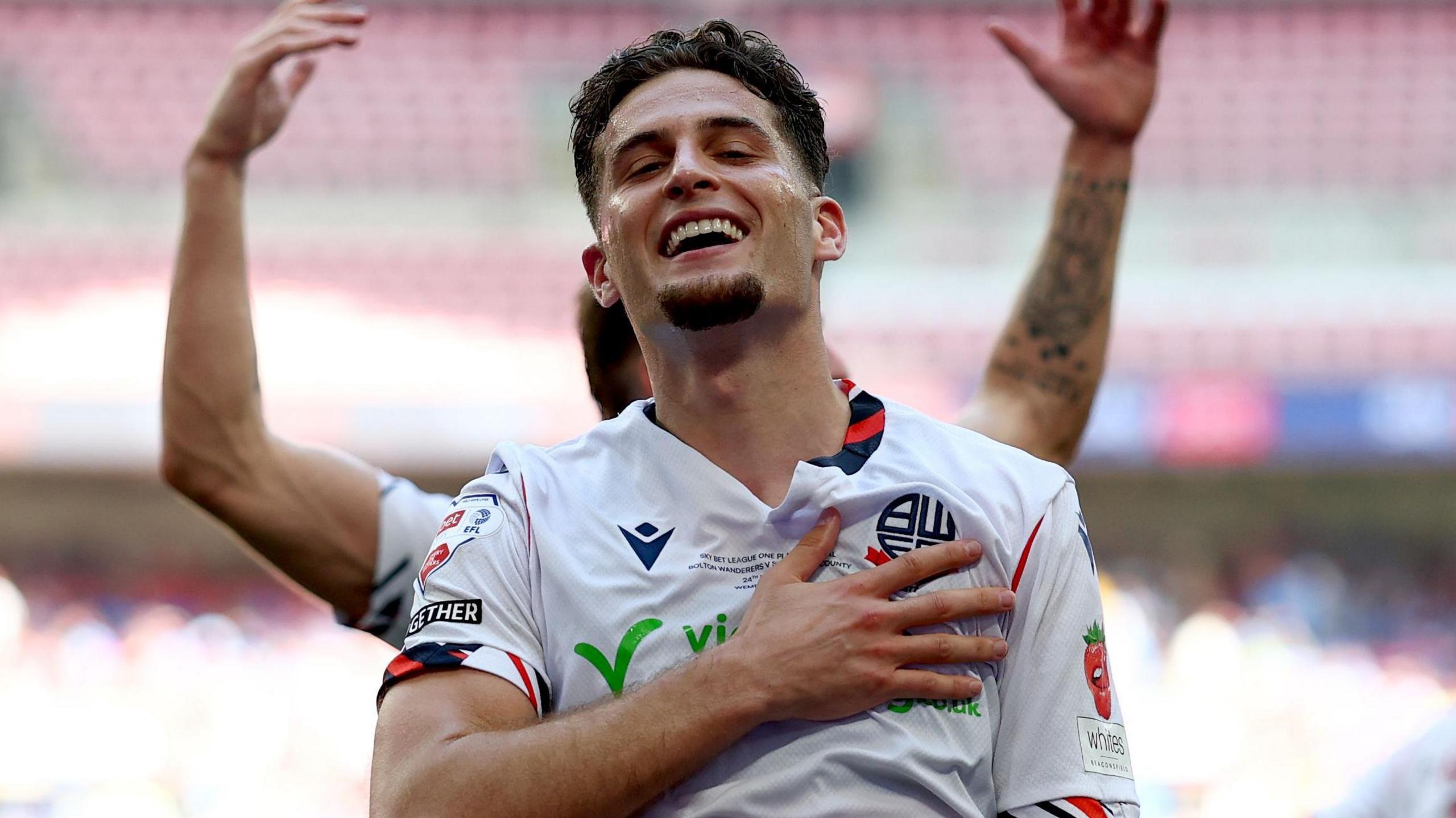Ruben Rodrigues celebrates scoring by holding badge