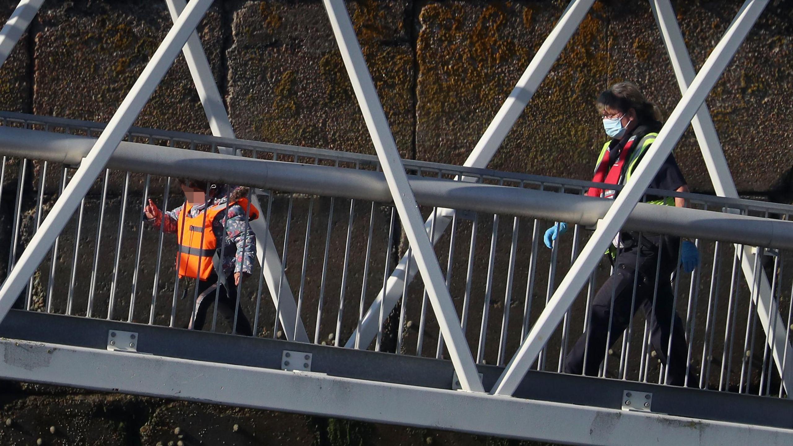 A young girl being escorted by a Border Force official