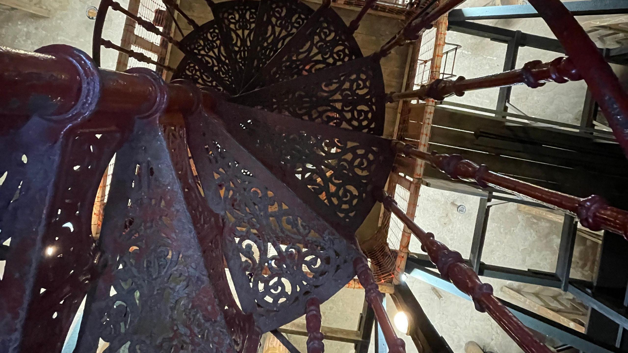 A downward view of a spiralling metal staircase inside the water tower