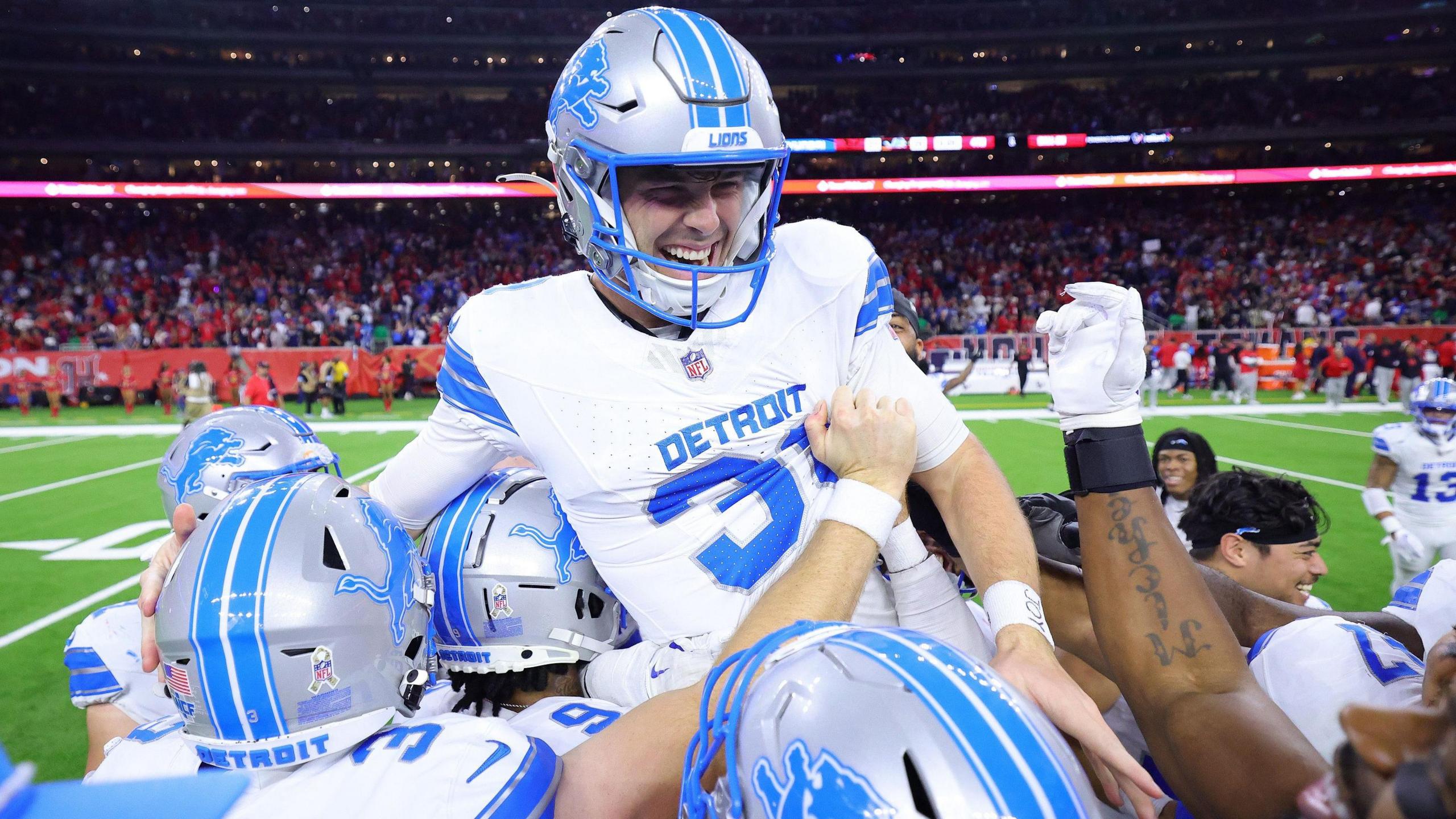 Detroit Lions players put kicker Jake Bates on their shoulders after he wins the game for them in Houston