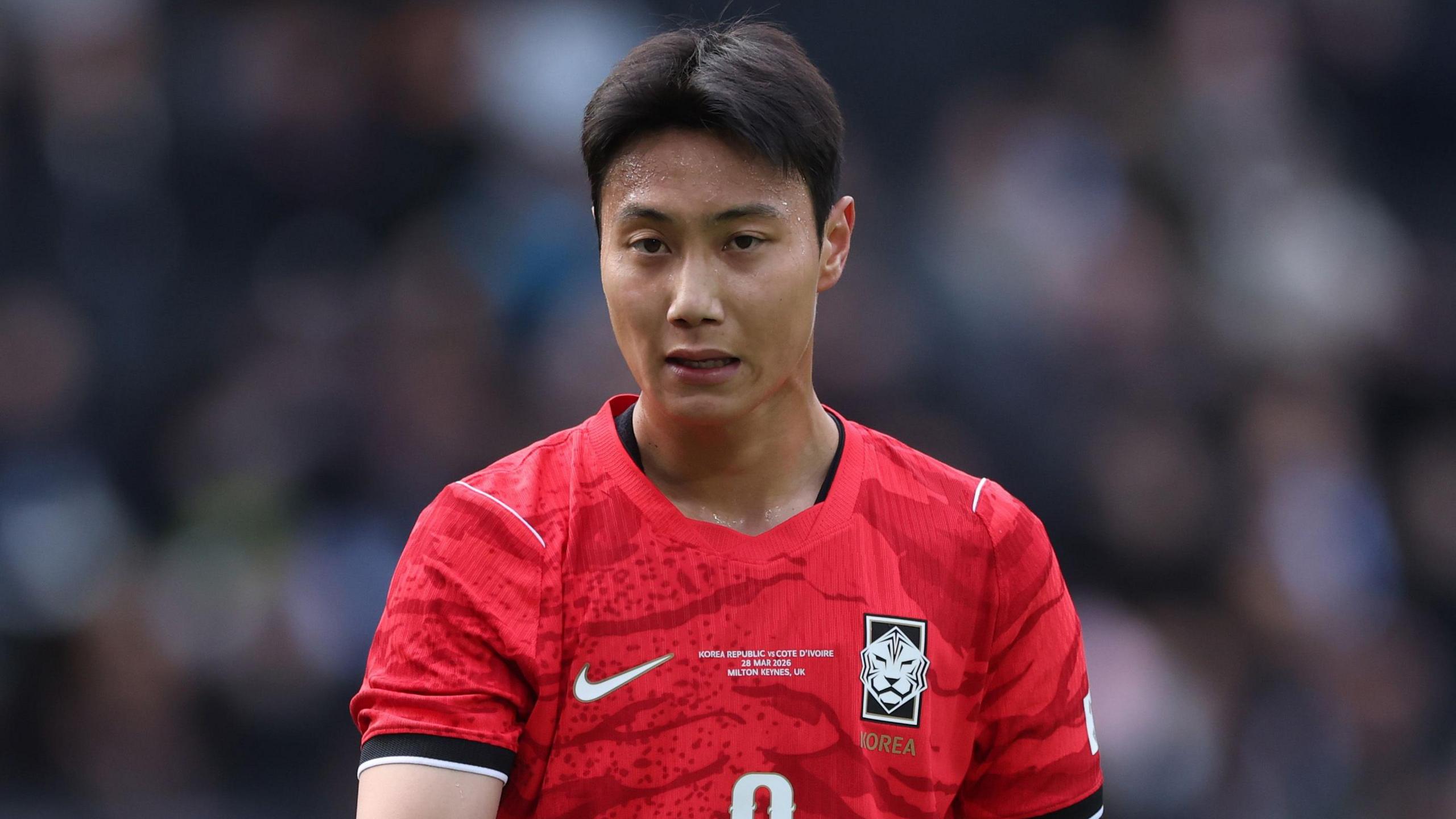 Paik Seung-ho looks serious while wearing South Korea's red shirt with black and white trim on the sleeves.