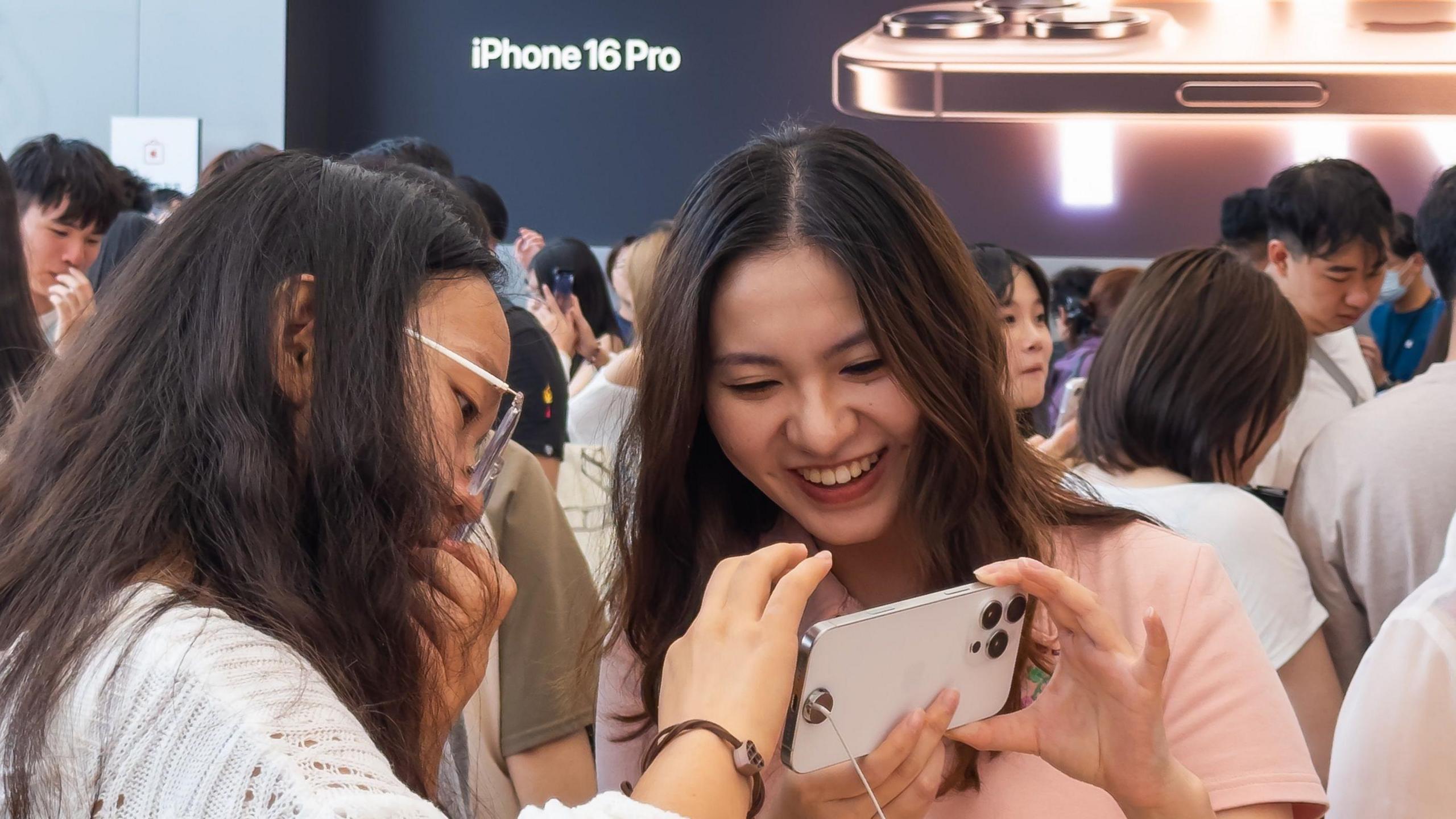 Shoppers look at iPhone 16 Pro at an Apple Store in Chengdu, China.