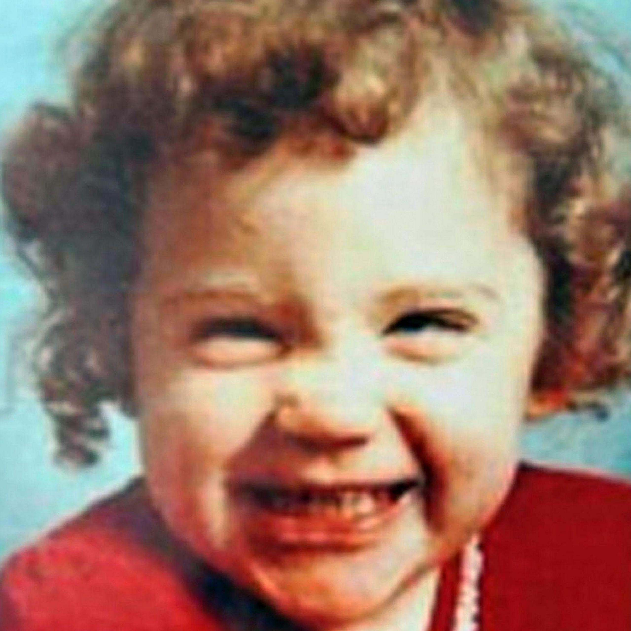 Katrice Lee grins at the camera. She has curly, light-brown hair and wears a red dress.