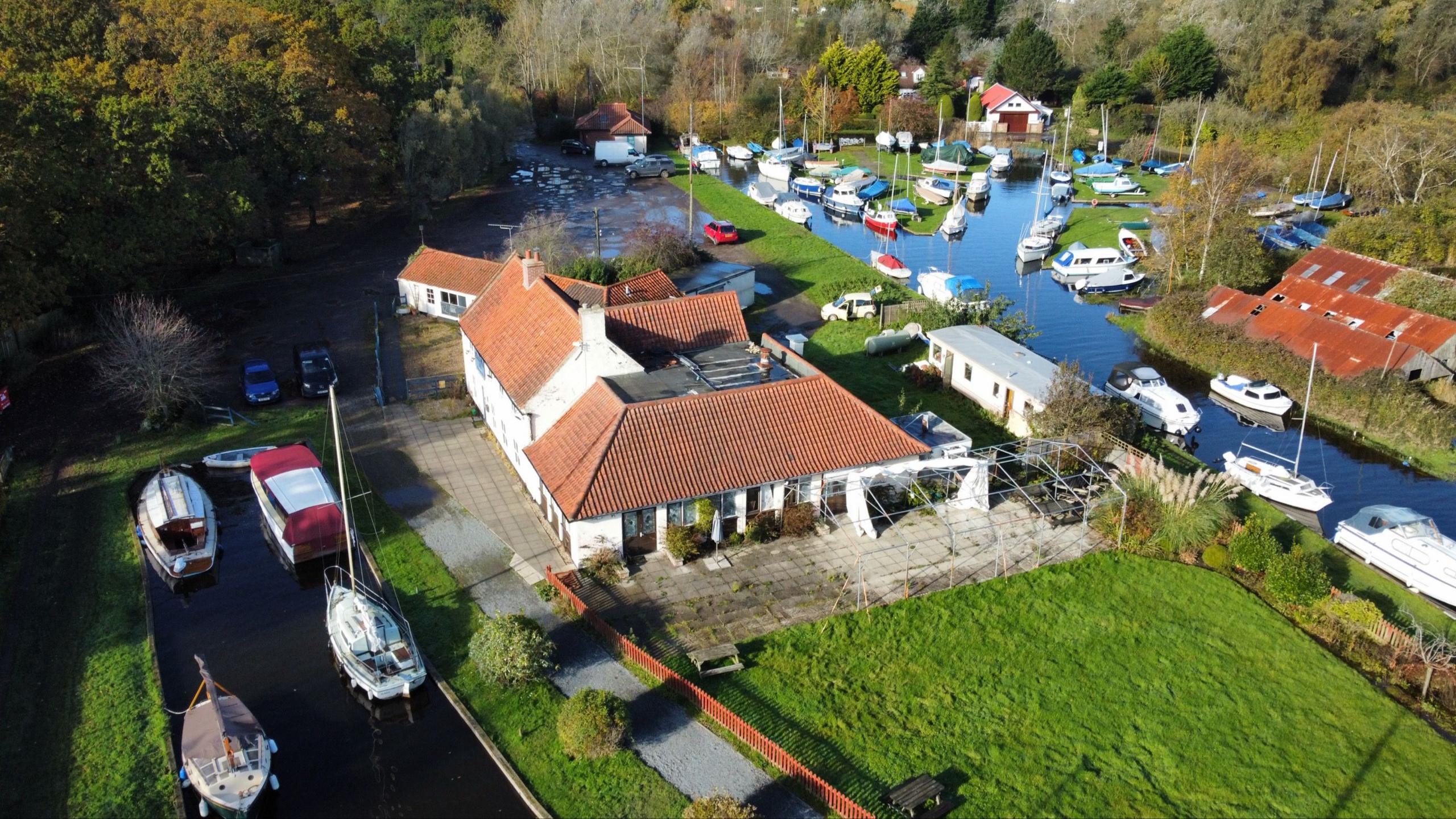 Ariel view of pub and broad waterway with boats