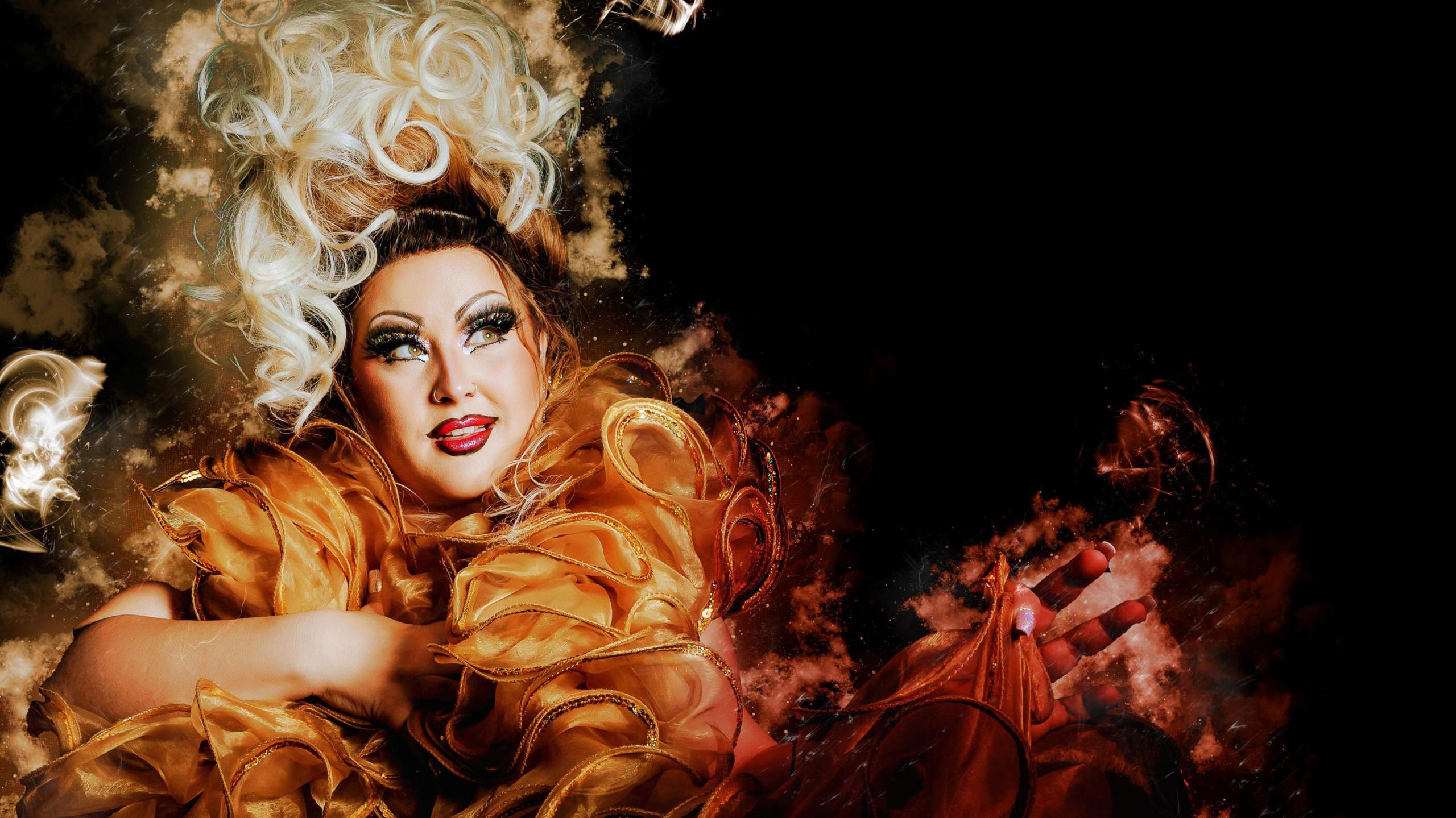 Mama Tasty - a drag act - wearing a bright blonde 60s-style wig and an extravagant orange dress