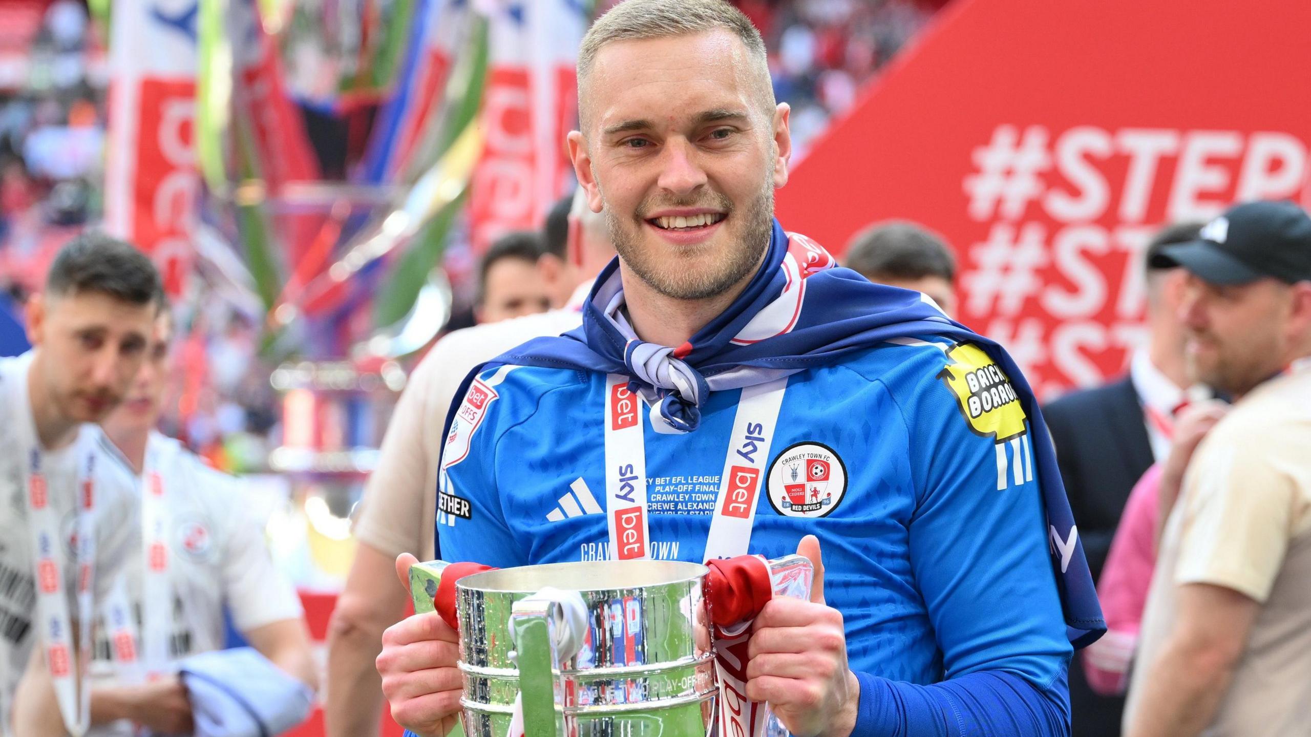 Ryan Sandford holds the League Two play-off final winners' trophy