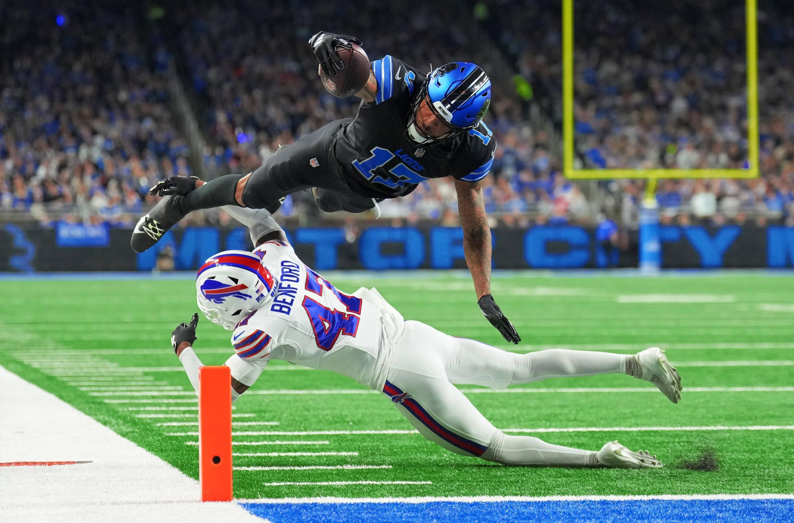 Tim Patrick of the Detroit Lions leaps over Christian Benford of the Buffalo Bills to score a touchdown in the second quarter at Ford Field