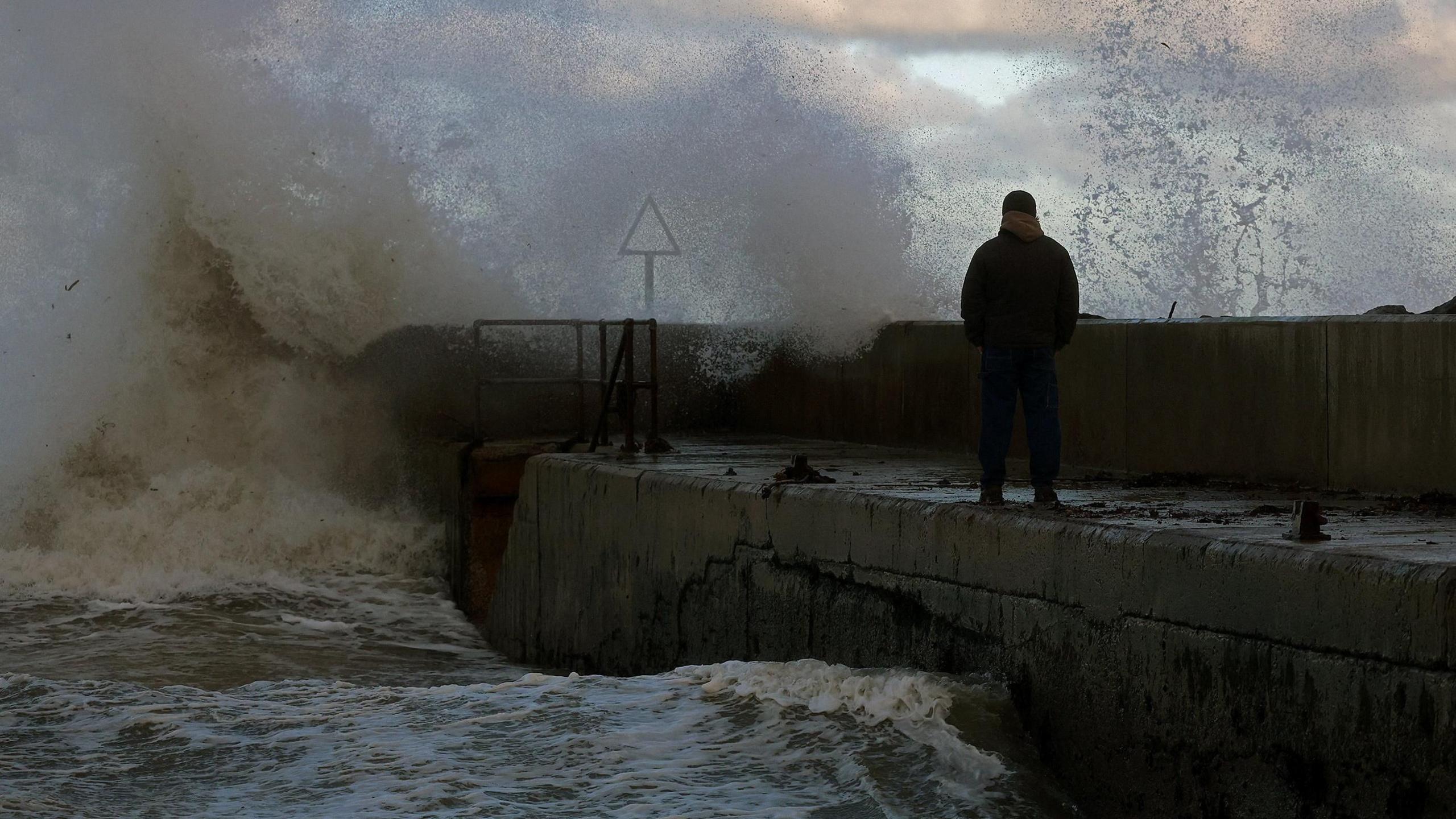 Waves crash on a pier in the coastal village of Cushendall, Northern Ireland