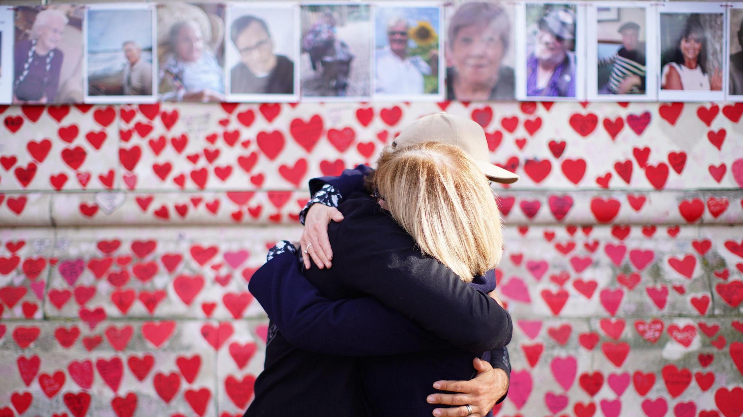 People hugging as they attend a ceremony marking the fifth anniversary of the Covid-19 pandemic at the National Covid Memorial Wall in London.