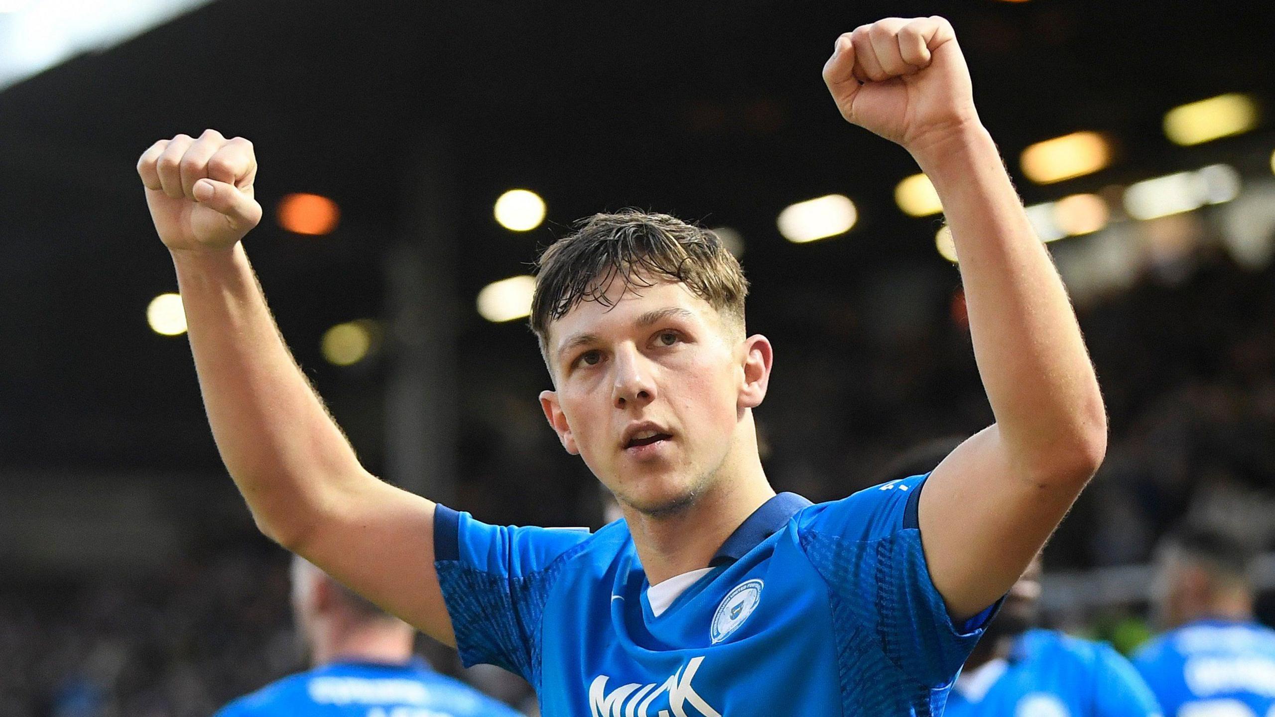 Harry Leonard, with both fists raised, celebrates a victory for Peterborough United