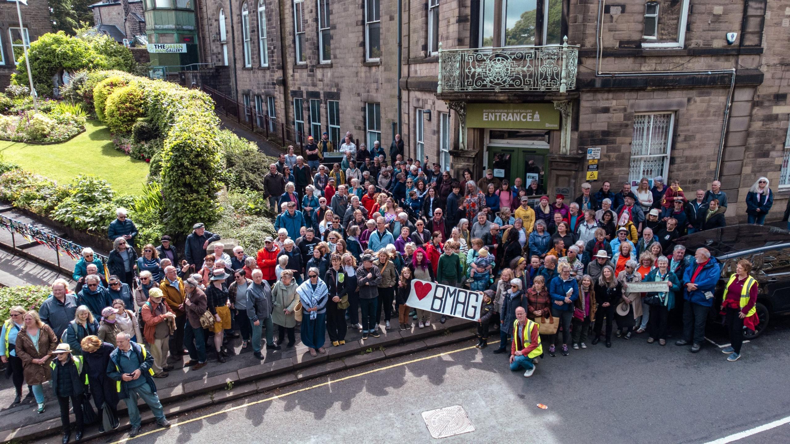 A group of people gathered outside the Peak Building in Buxton