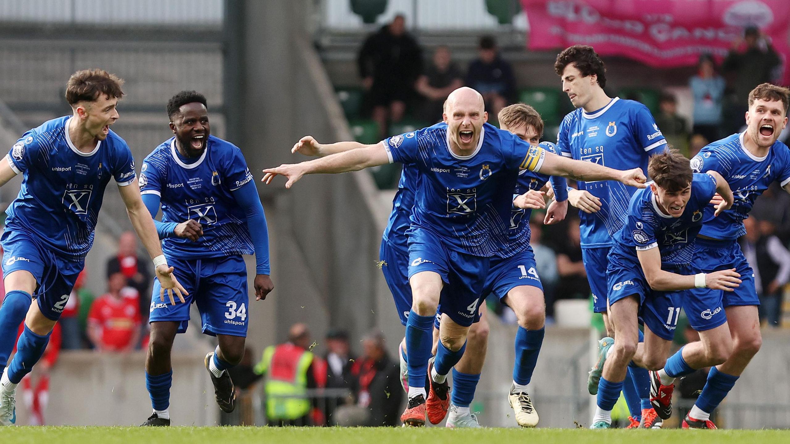 Dungannon Swifts players run to celebrate their Irish Cup win over Cliftonville
