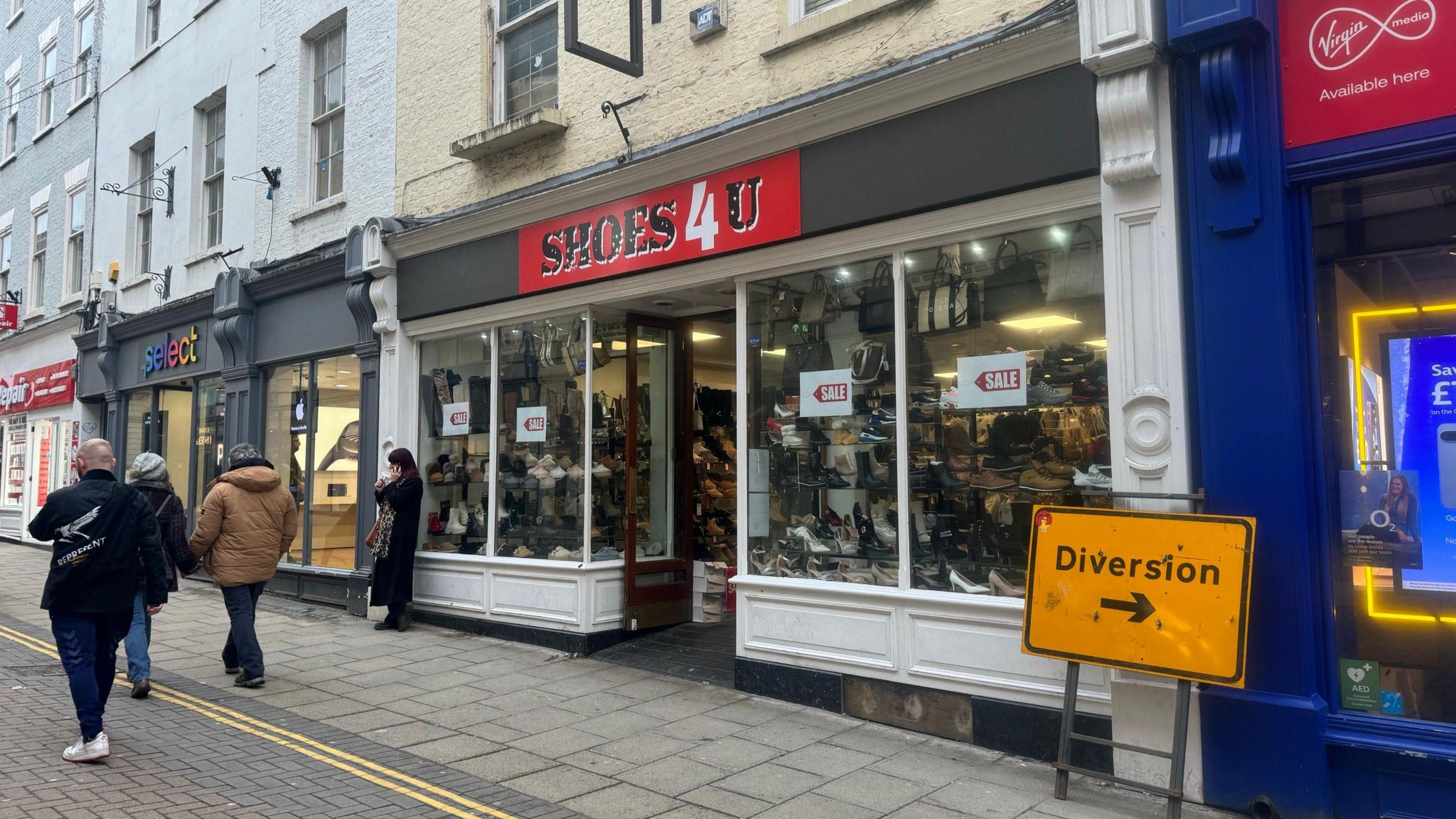 Street view of shop Shoes 4 U, the front window shows rows and rows of shoes 