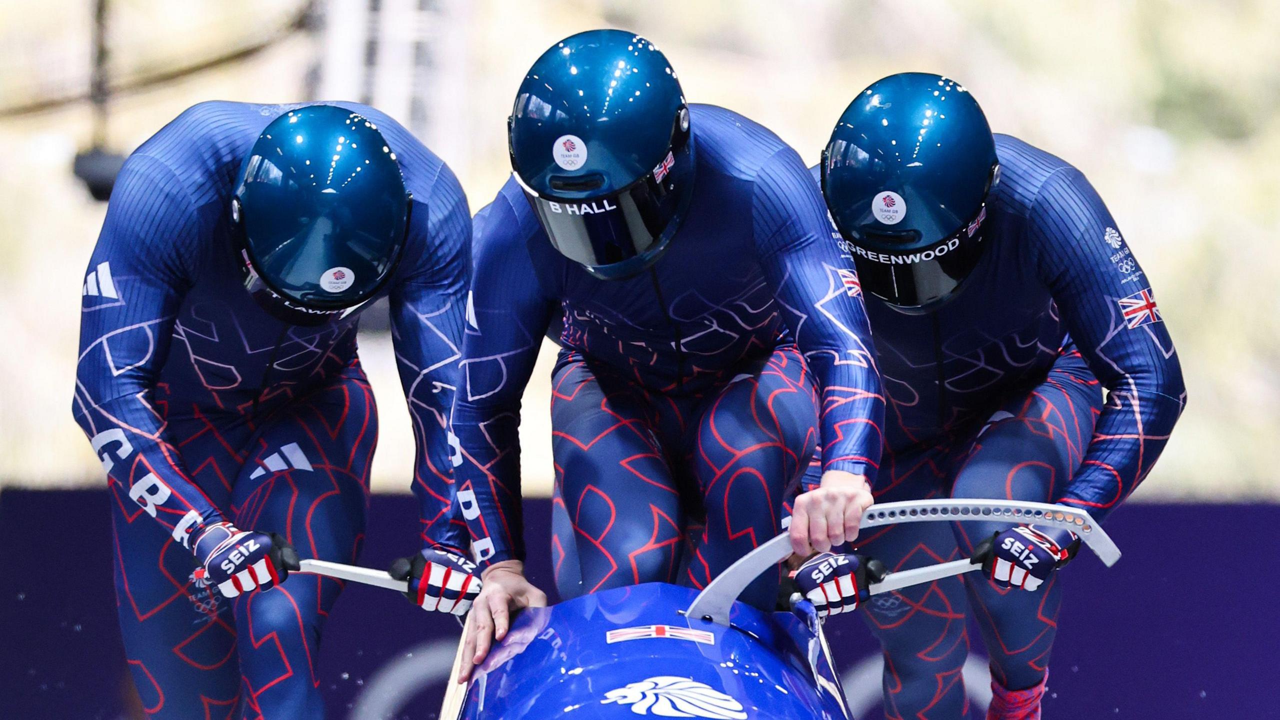 Team GB push the sled in the first heat of the bobsleigh at Cortina sliding centre