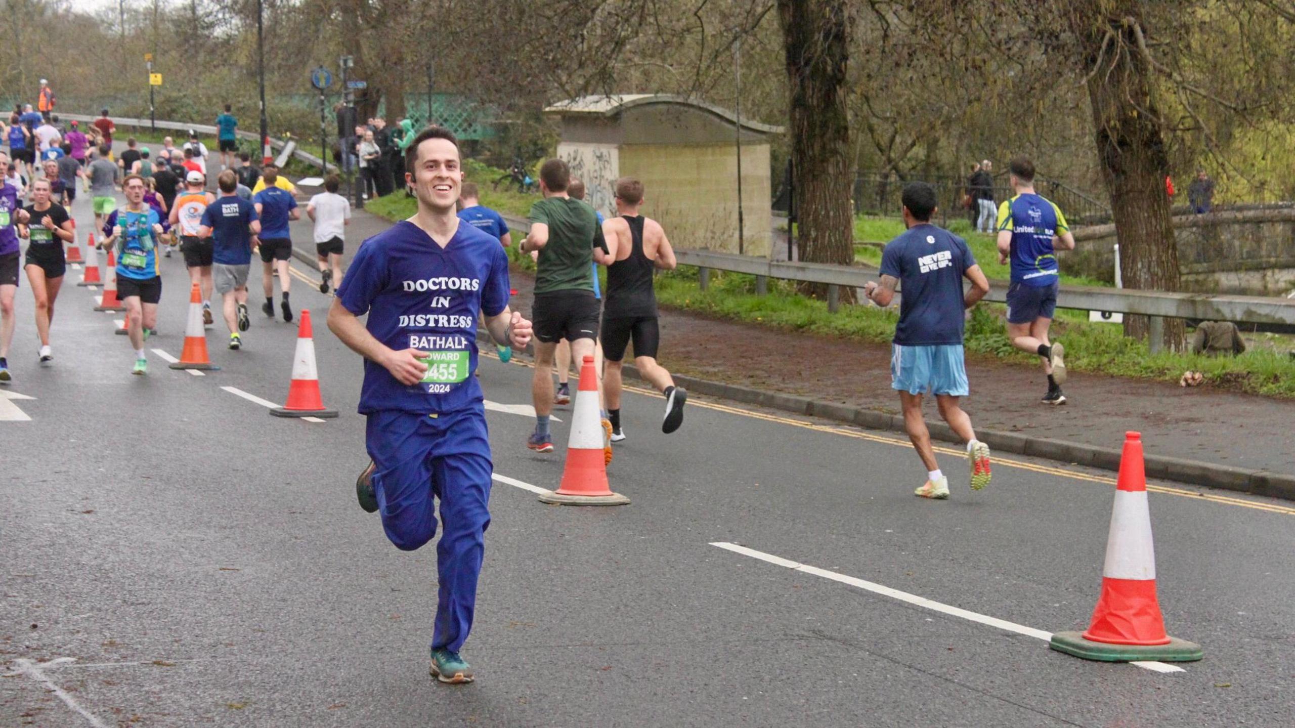 Mr Hutchison running in a half marathon in his scrubs 