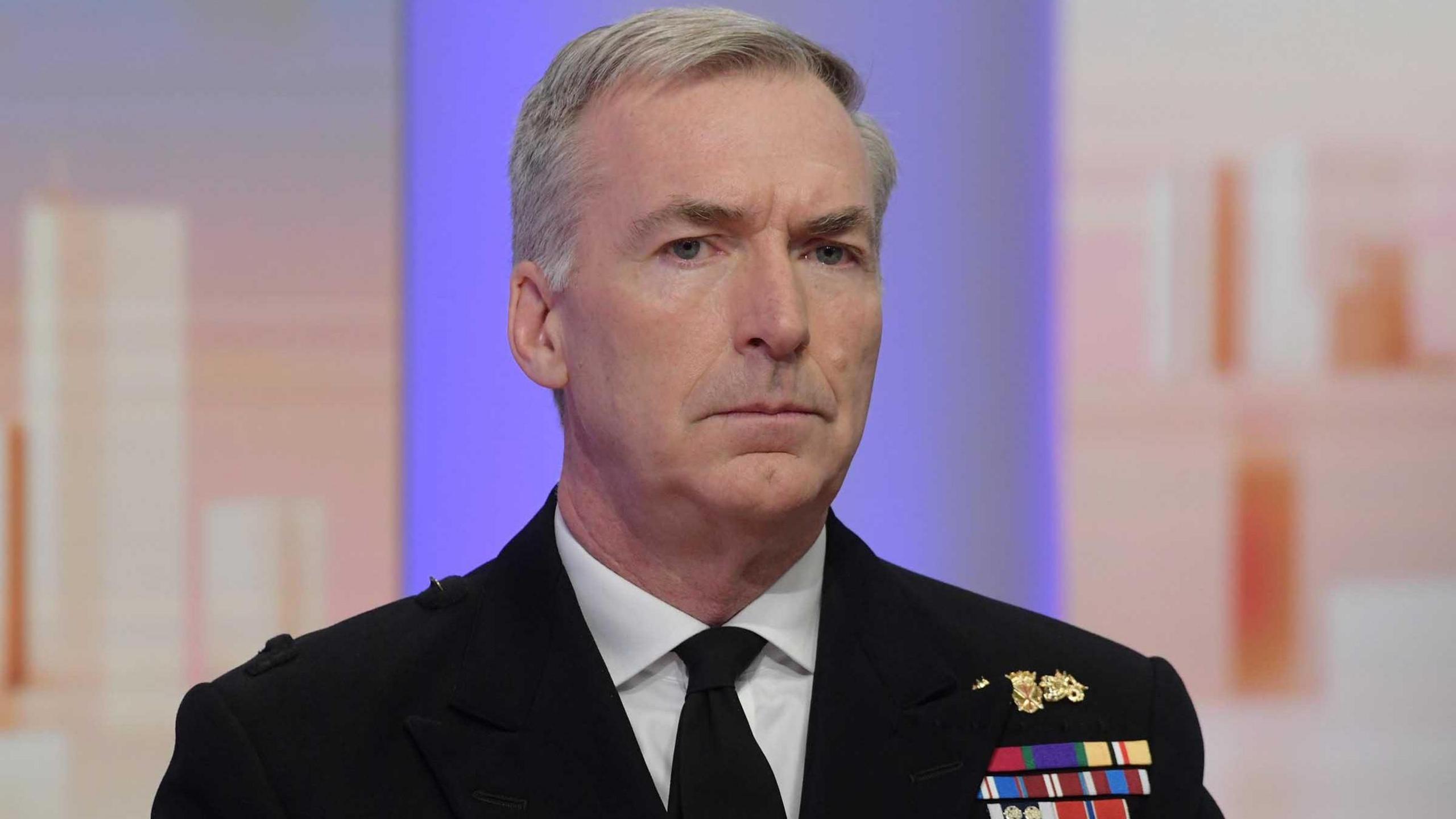 Admiral Sir Tony Radakin wears a blazer, white shirt, and black suit jacket with military medals, faces the camera 