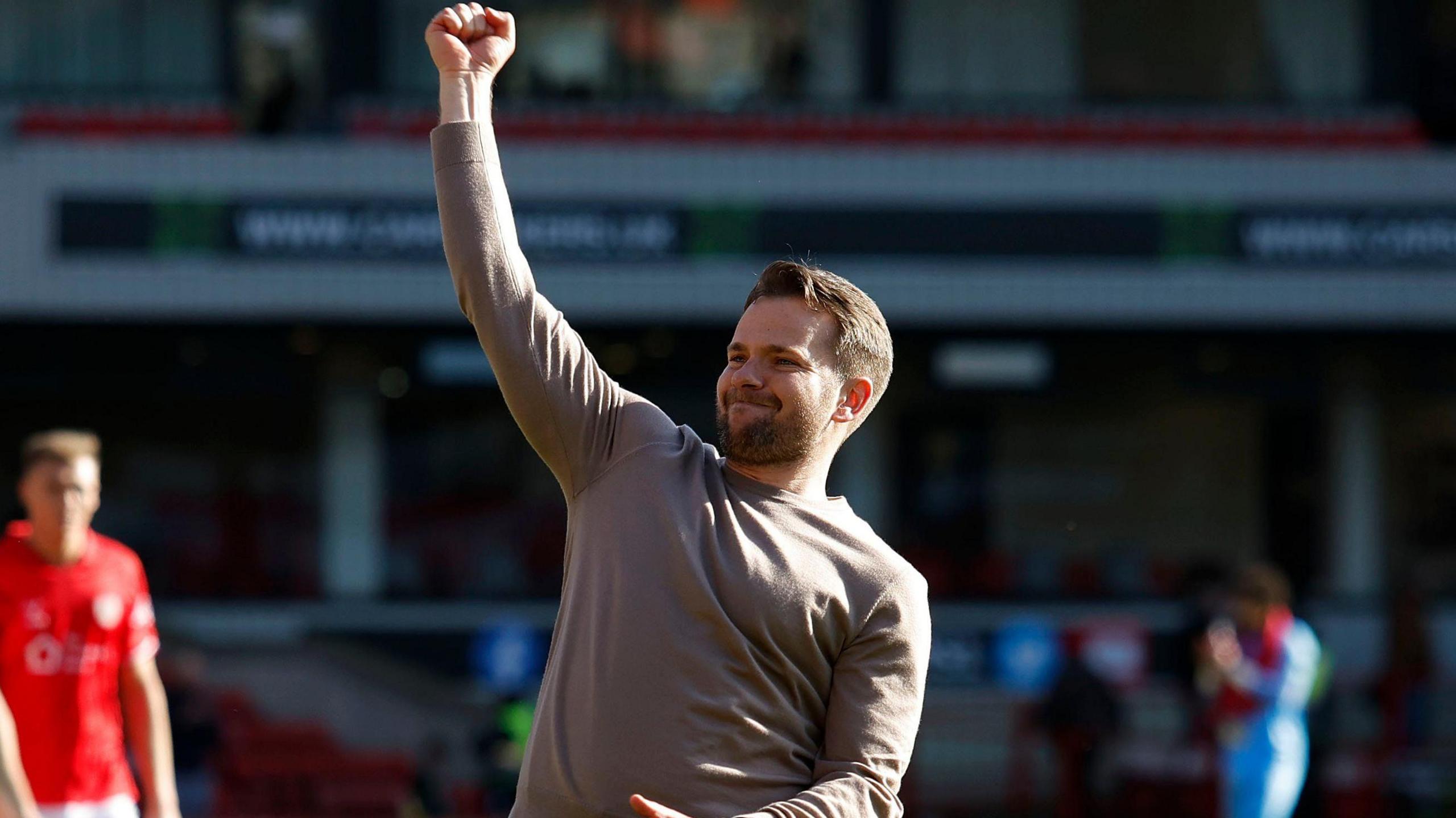 Plymouth Argyle boss Tom Cleverley punching the air in delight towards his side's supporters after their victory against Barnsley.