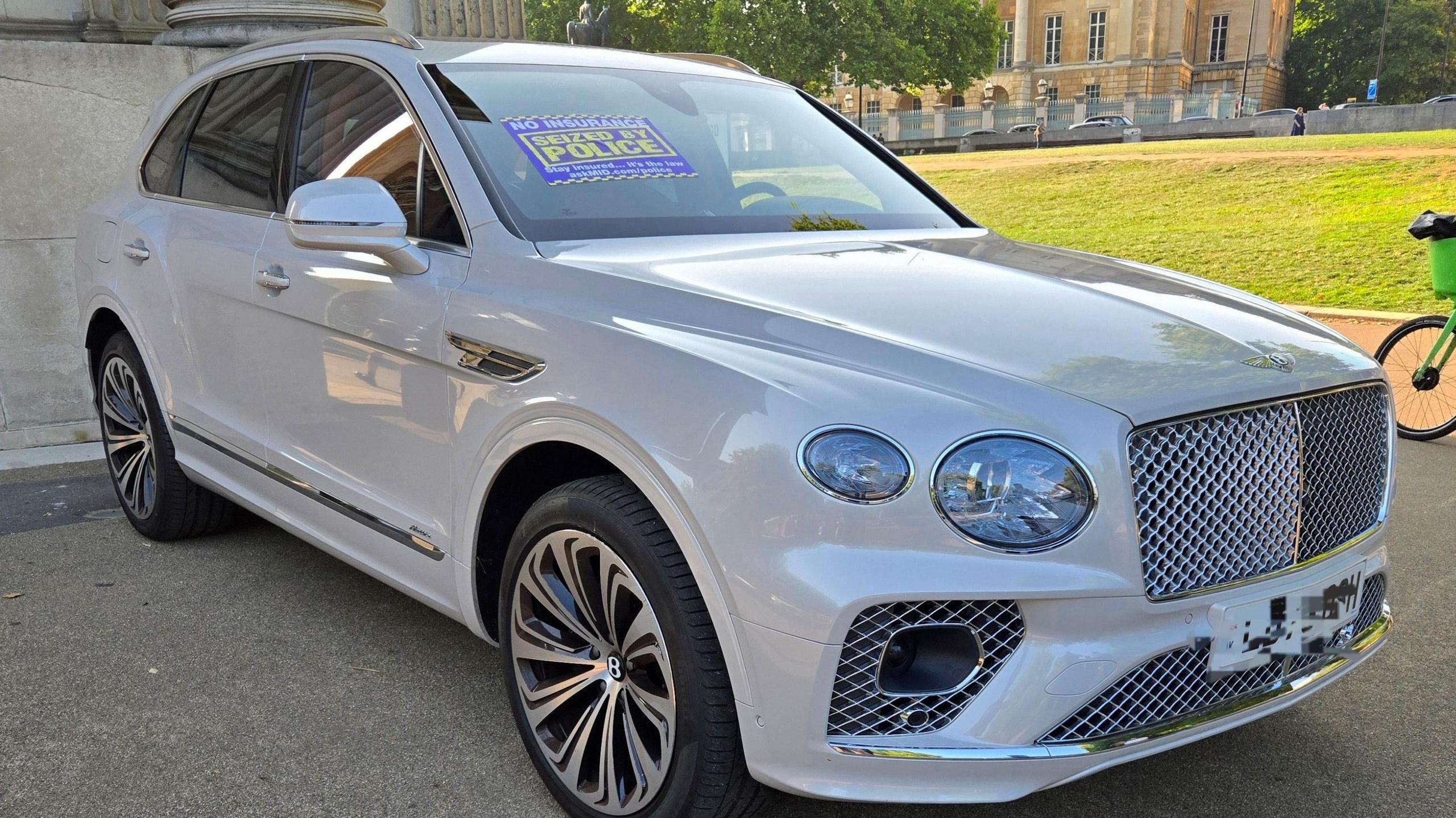 A white Bentley with a sign that reads: "Seized by Police" on the bonnet.