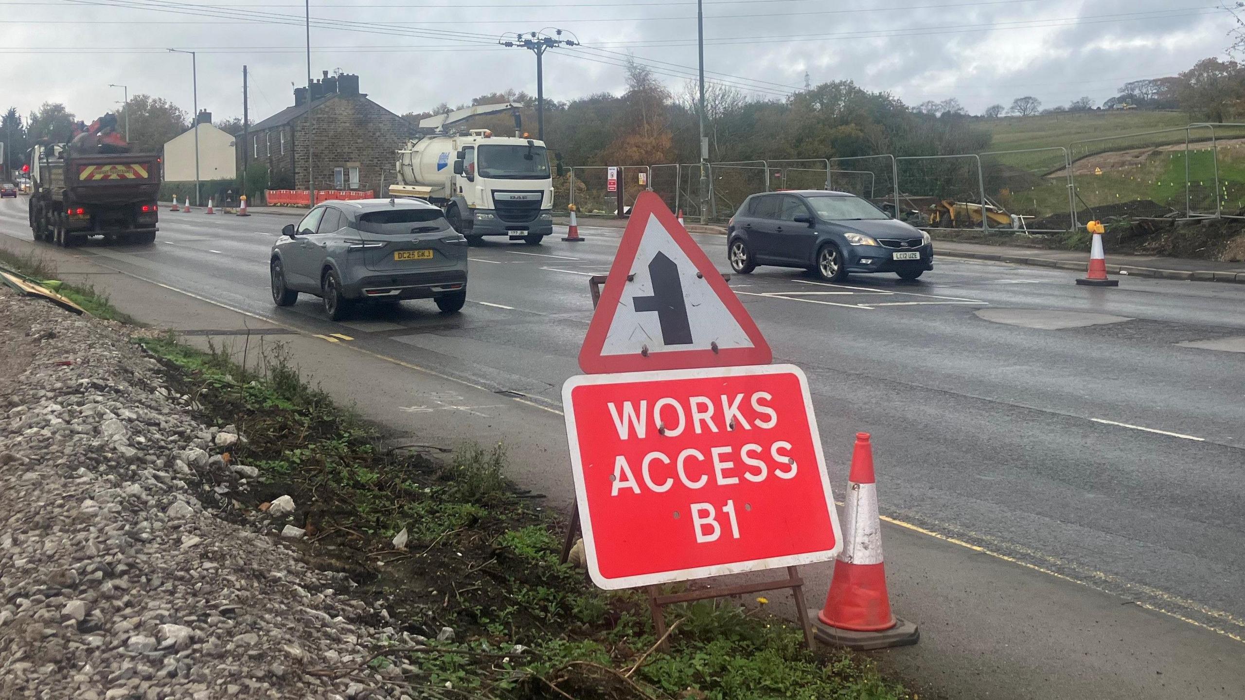 Photograph of roadworks on the A57 between the villages of Mottram and Holingworth. The image shows traffic, roadworks signs and traffic cones.