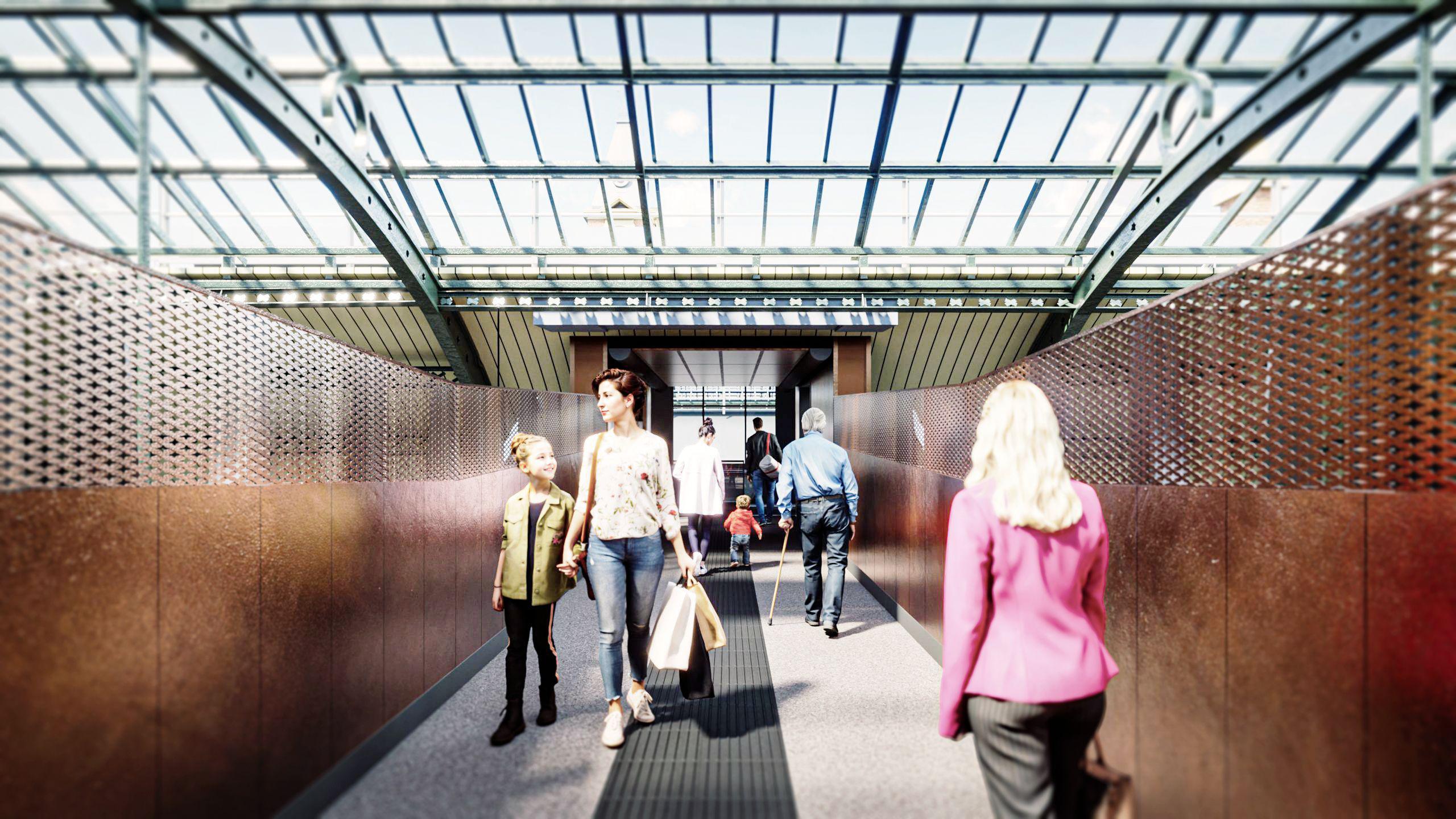 A CGI of people walking over the new footbridge being built at Darlington station. The bridge has copper coloured walls that stand roughly shoulder height which gives way to a weave allowing people to look down on the station.