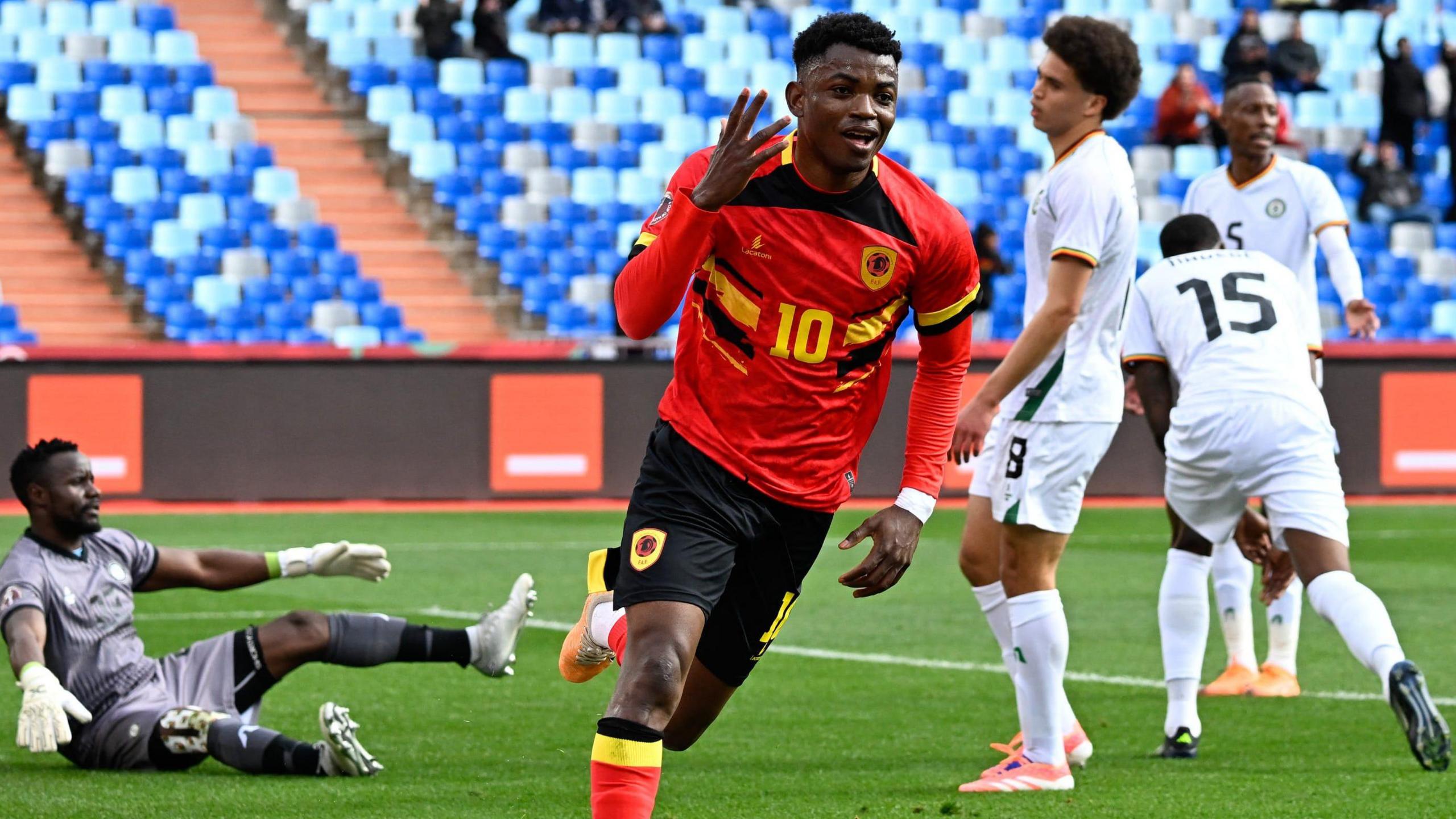 Angola footballer Gelson Dala, wearing a red, yellow and black kit, raises a hand to celebrate after scoring against Zimbabwe at the Africa Cup of Nations 2025 football tournament