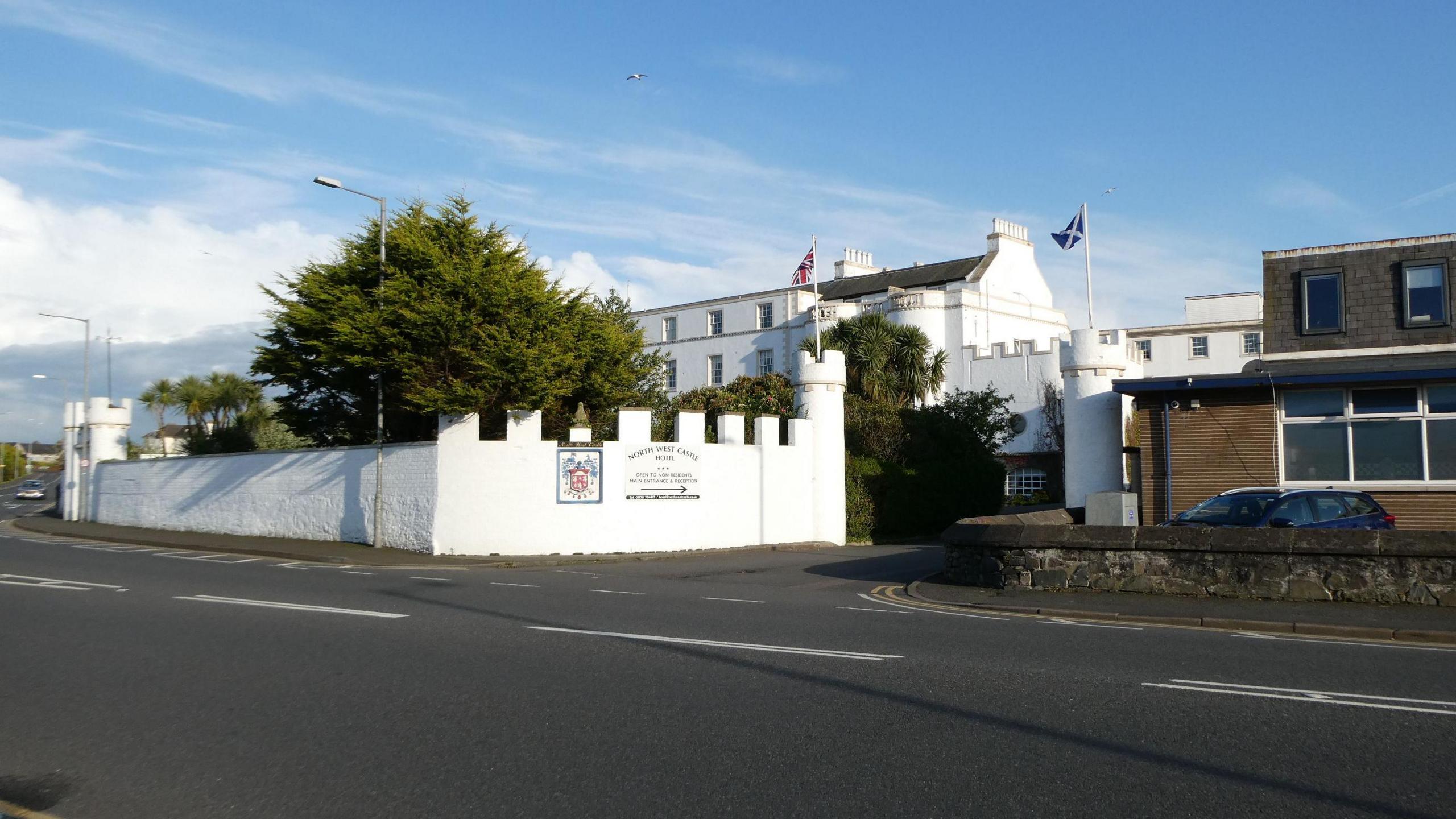 A white stone hotel building against a blue sky