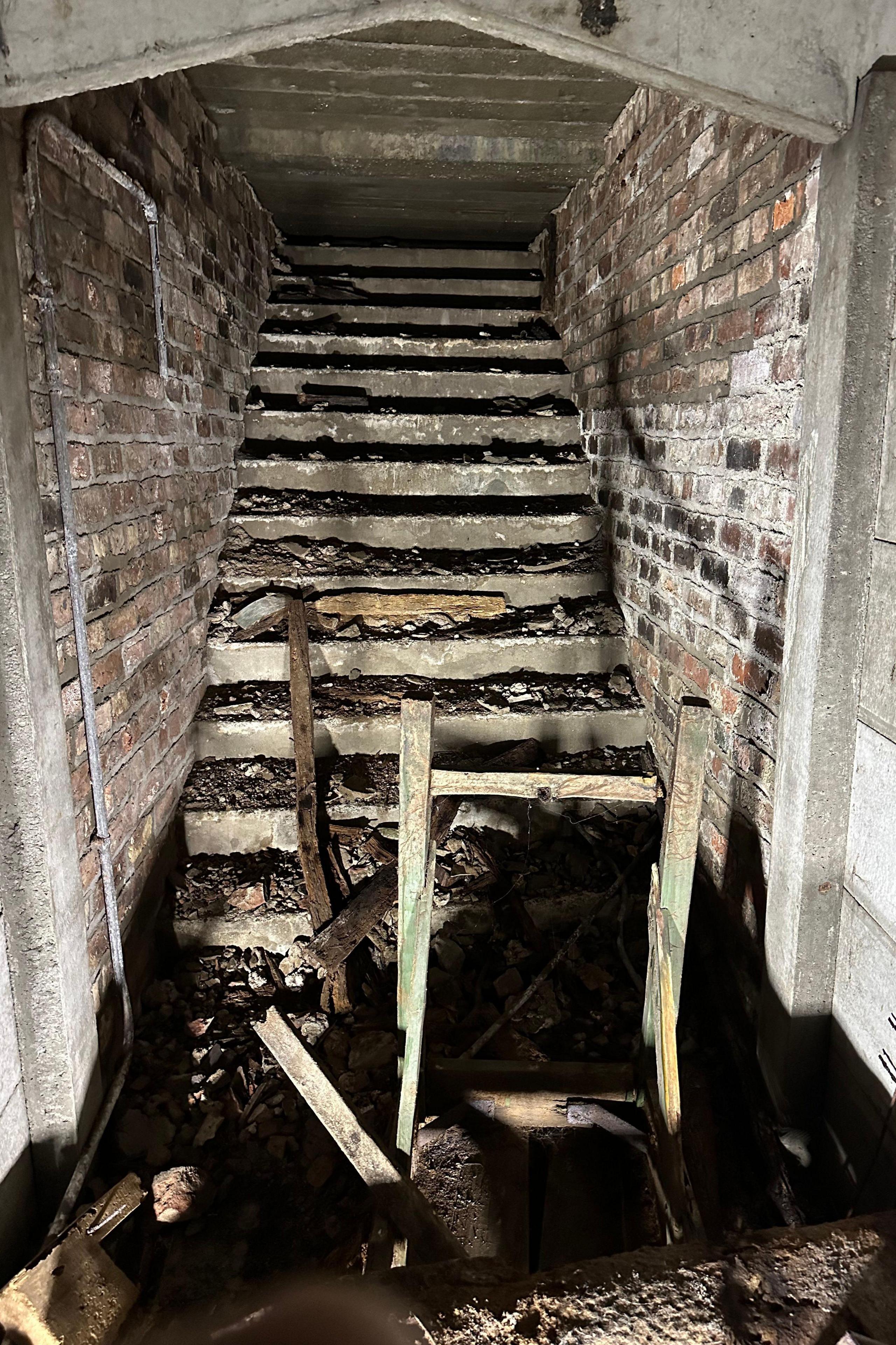 A dimly lit concrete staircase leading to the tunnels. 