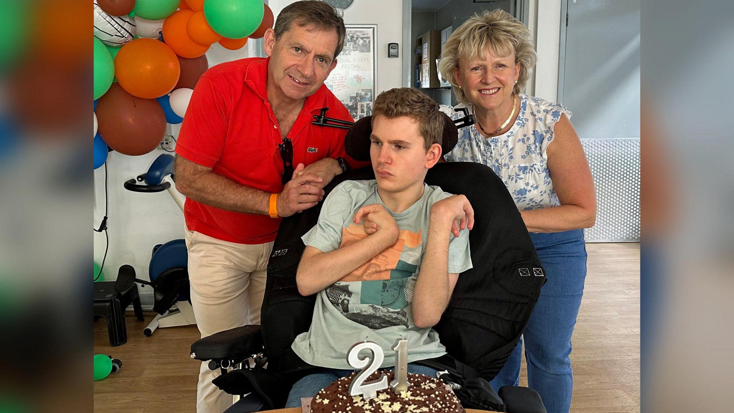 Mikey with his parents and a birthday cake