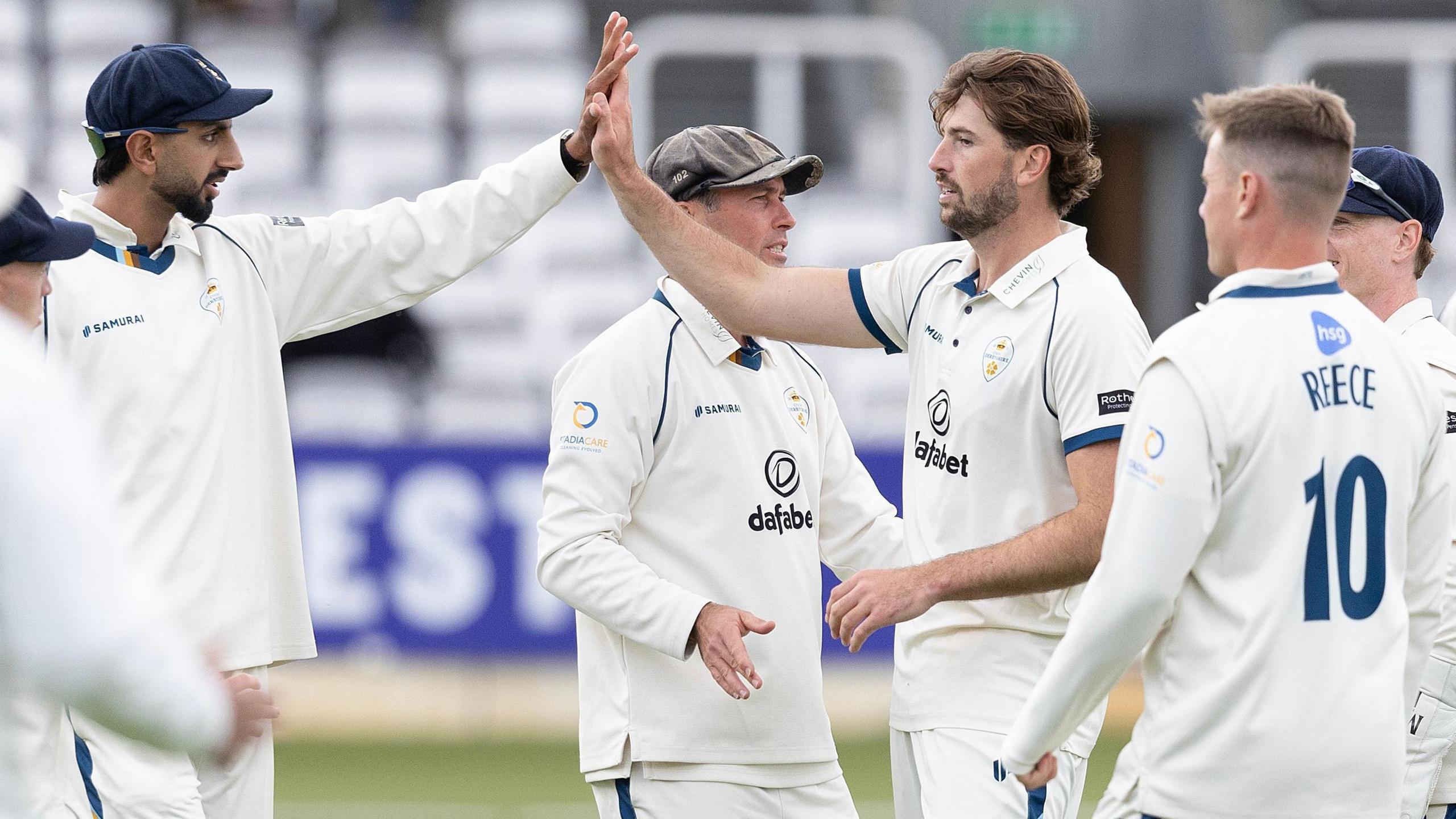 Ben Aitchison high fives a Derbyshire team-mate after taking a wicket against Middlesex at Lord's