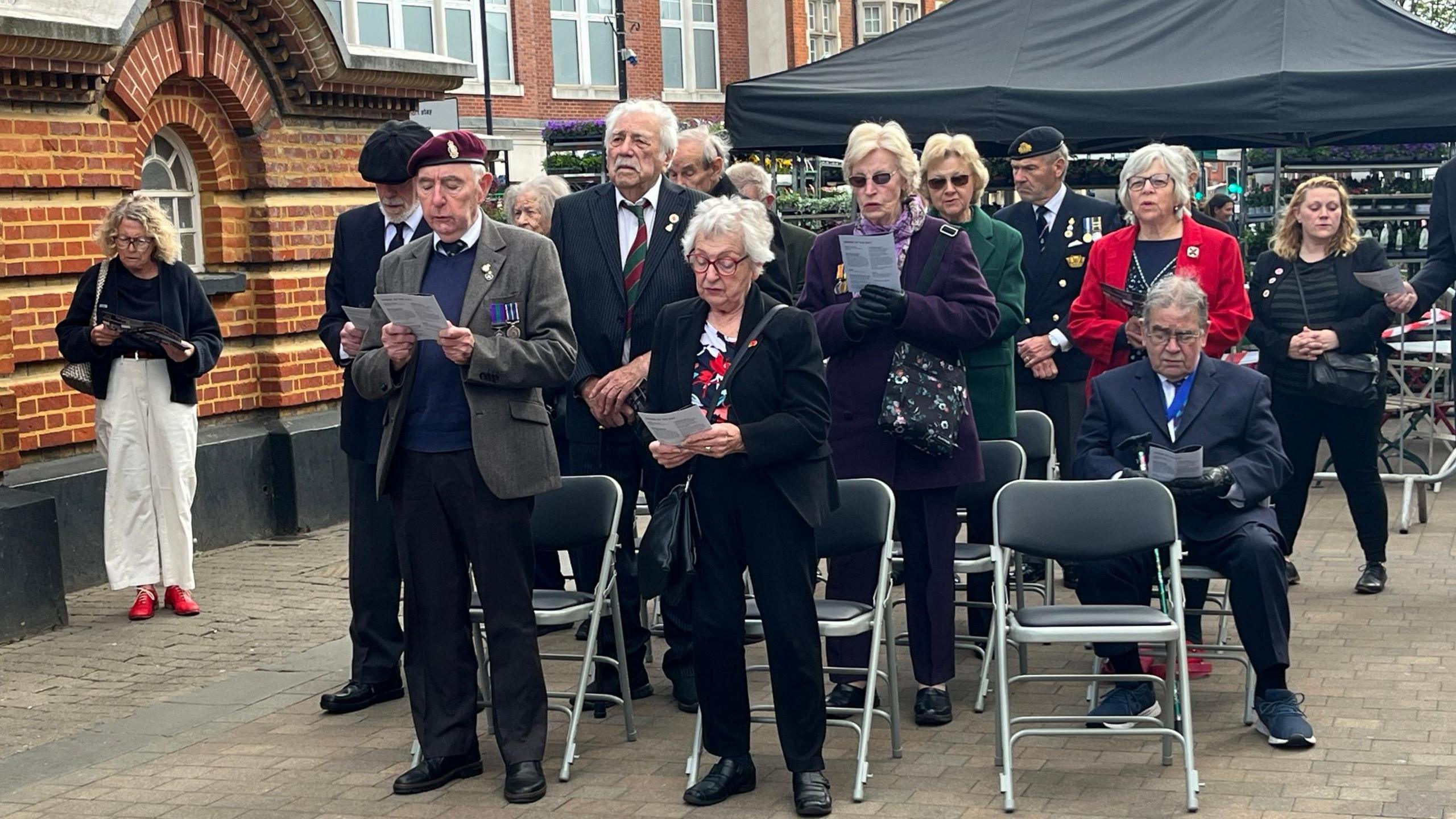 A crowd of people gathered to take part in a VE Day service in Epsom