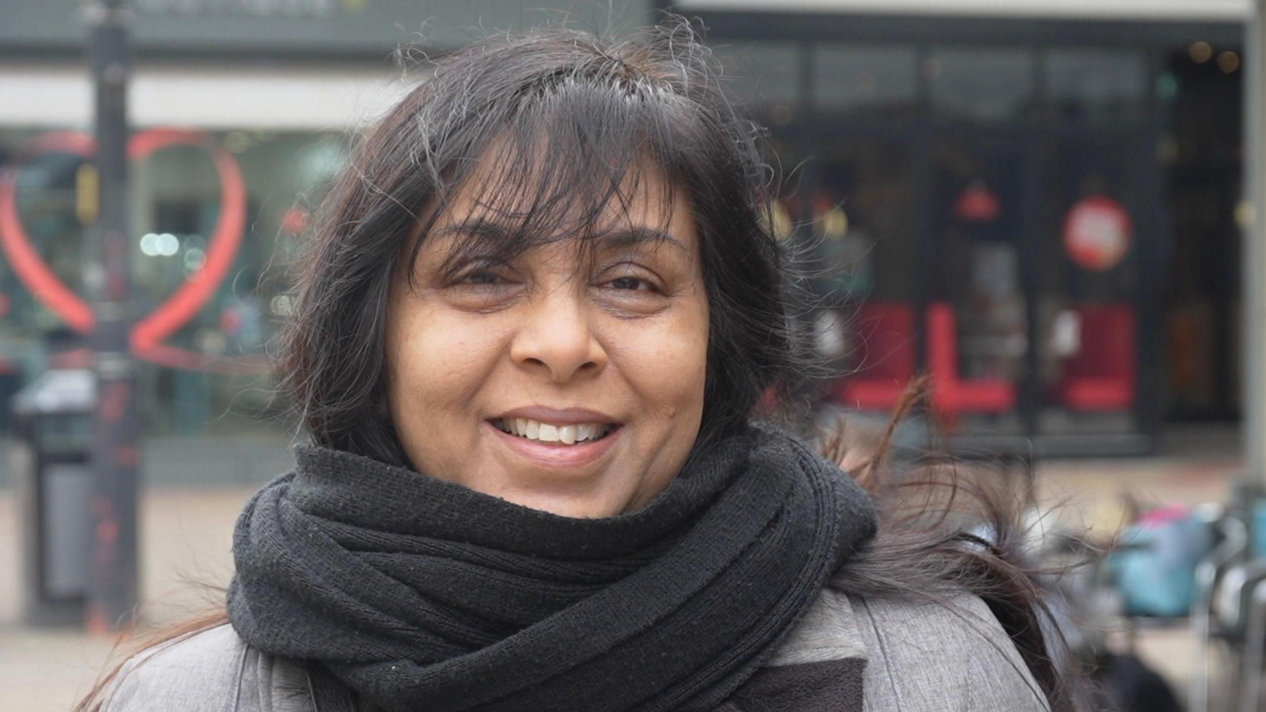 Rasna Patel in Harlow town centre, wearing a scarf and smiling