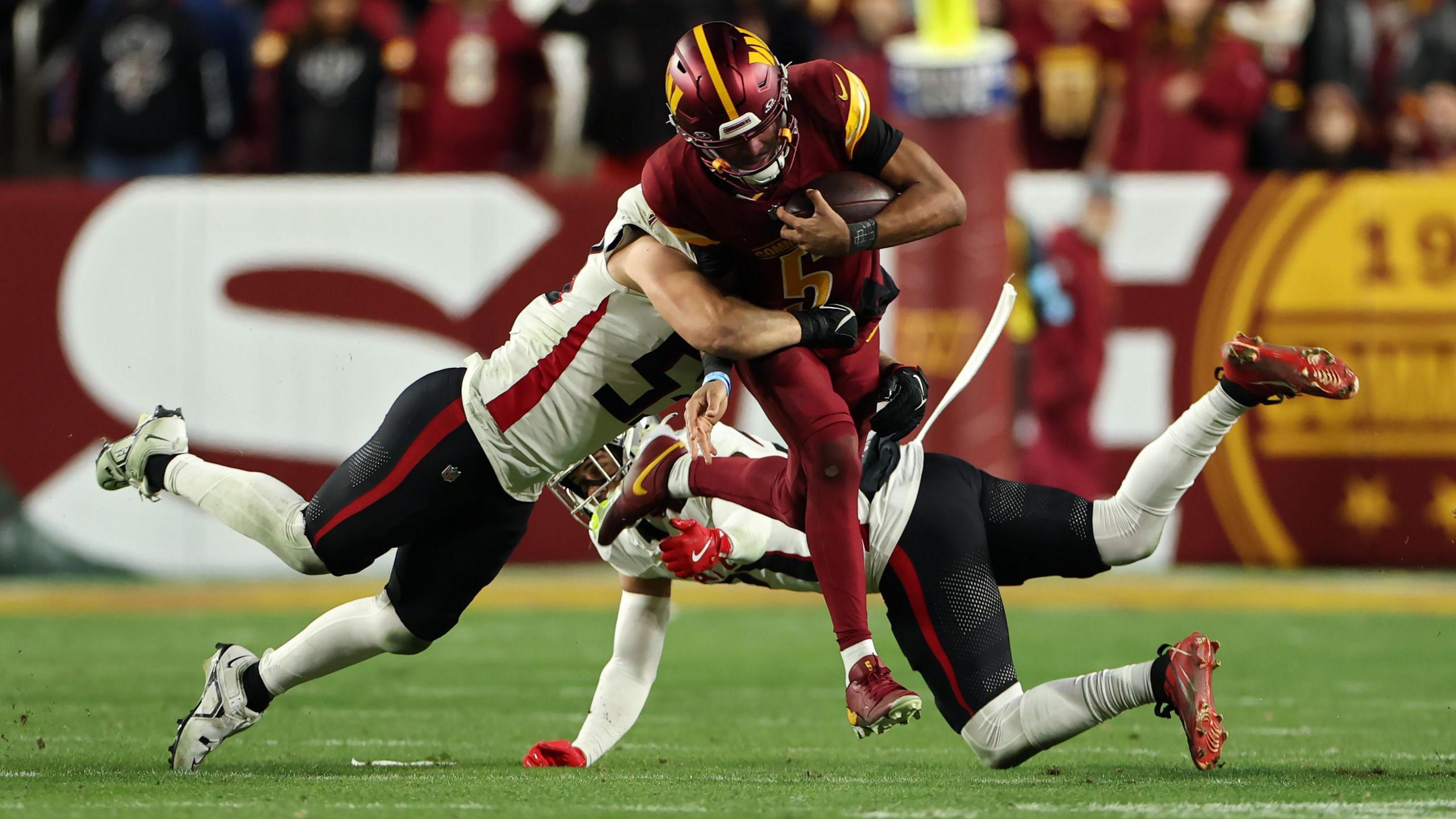 Washington Commanders quarterback Jayden Daniels makes a tough run against the Atlanta Falcons