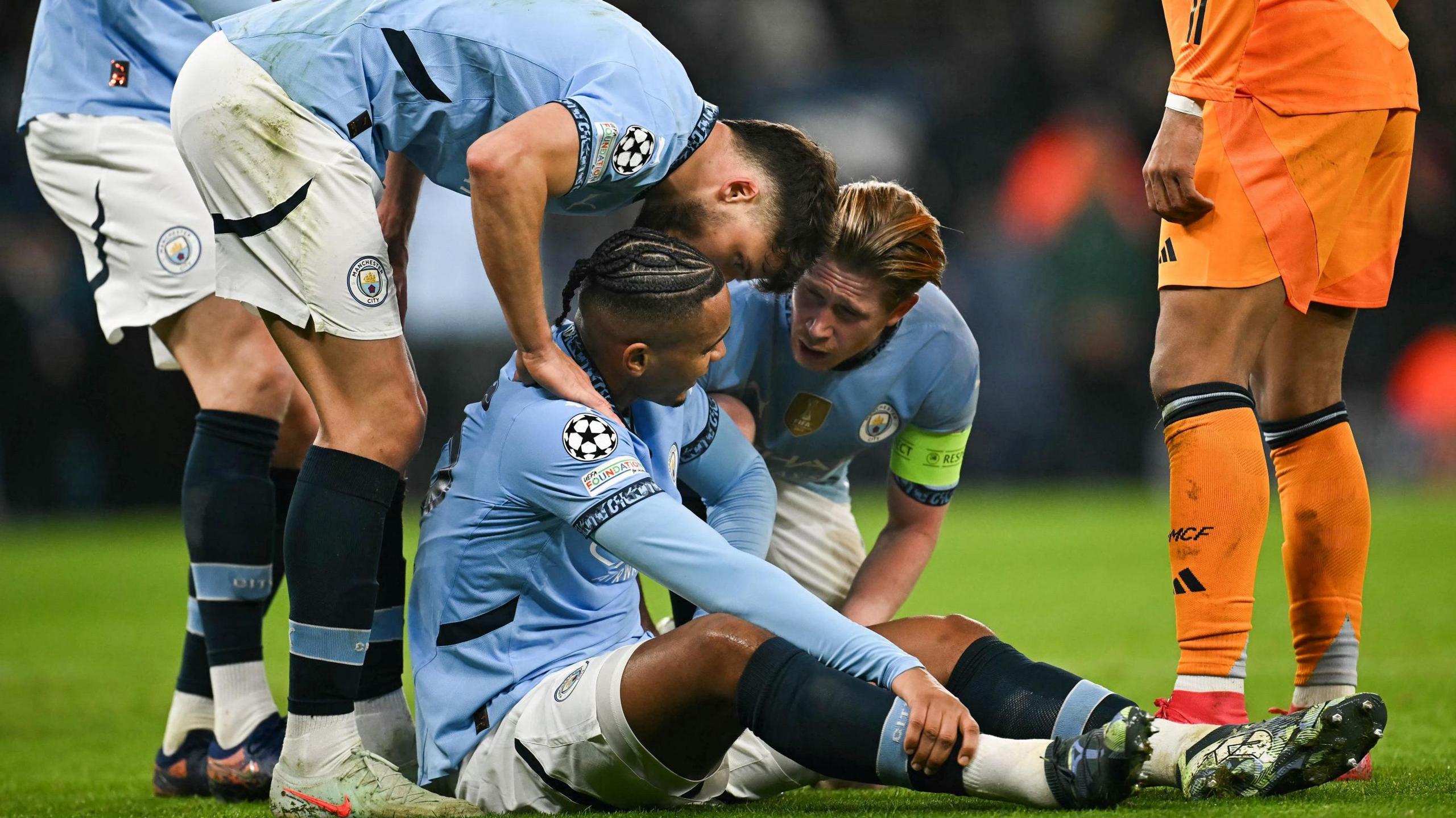 Manchester City's Manuel Akanji sits down on the pitch after sustaining an injury against Real Madrid