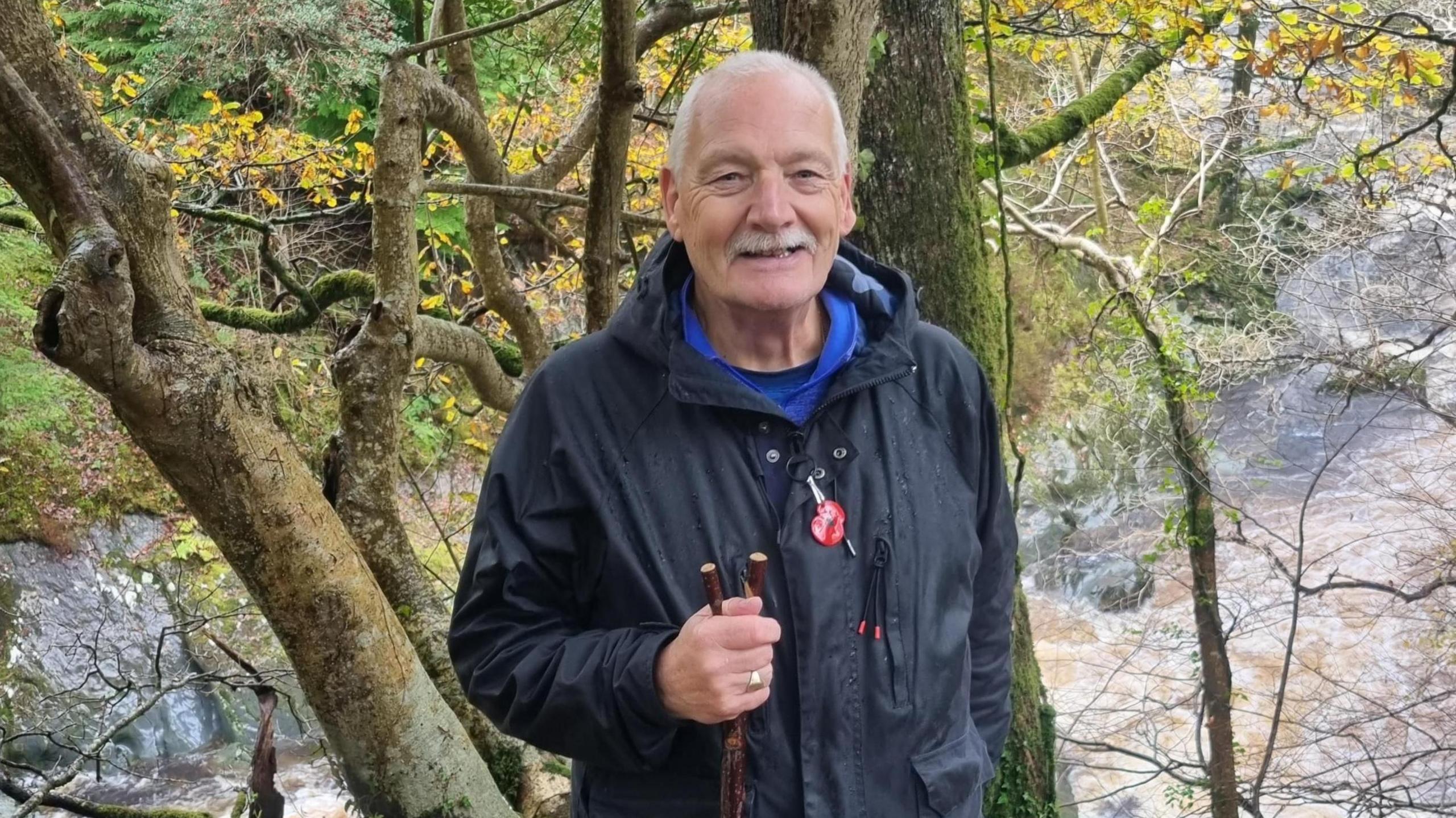 Paul Nelson stops for a photo in the woods while out for a walk