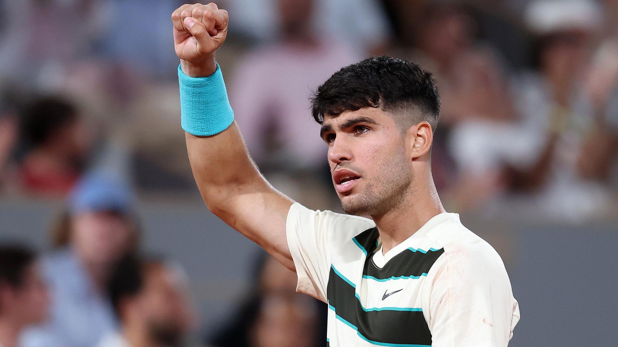 Carlos Alcaraz raises his right arm