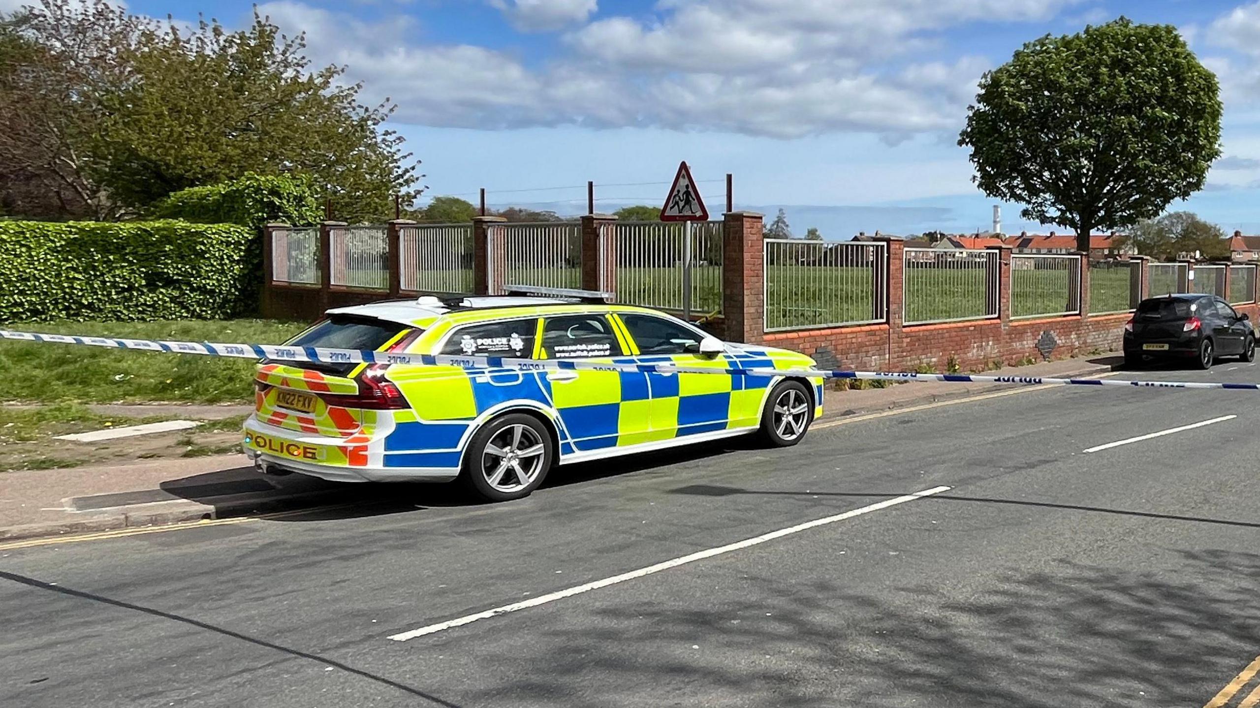 Police car and police tape cordon