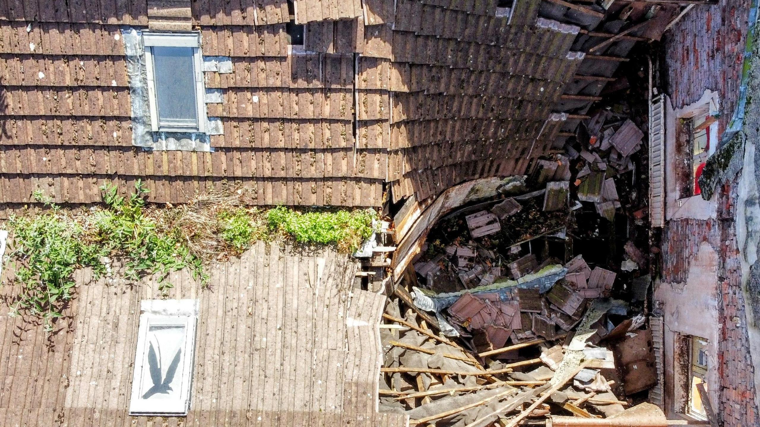 The roof of the property has partially fallen in - revealing the inside which is full of debris.