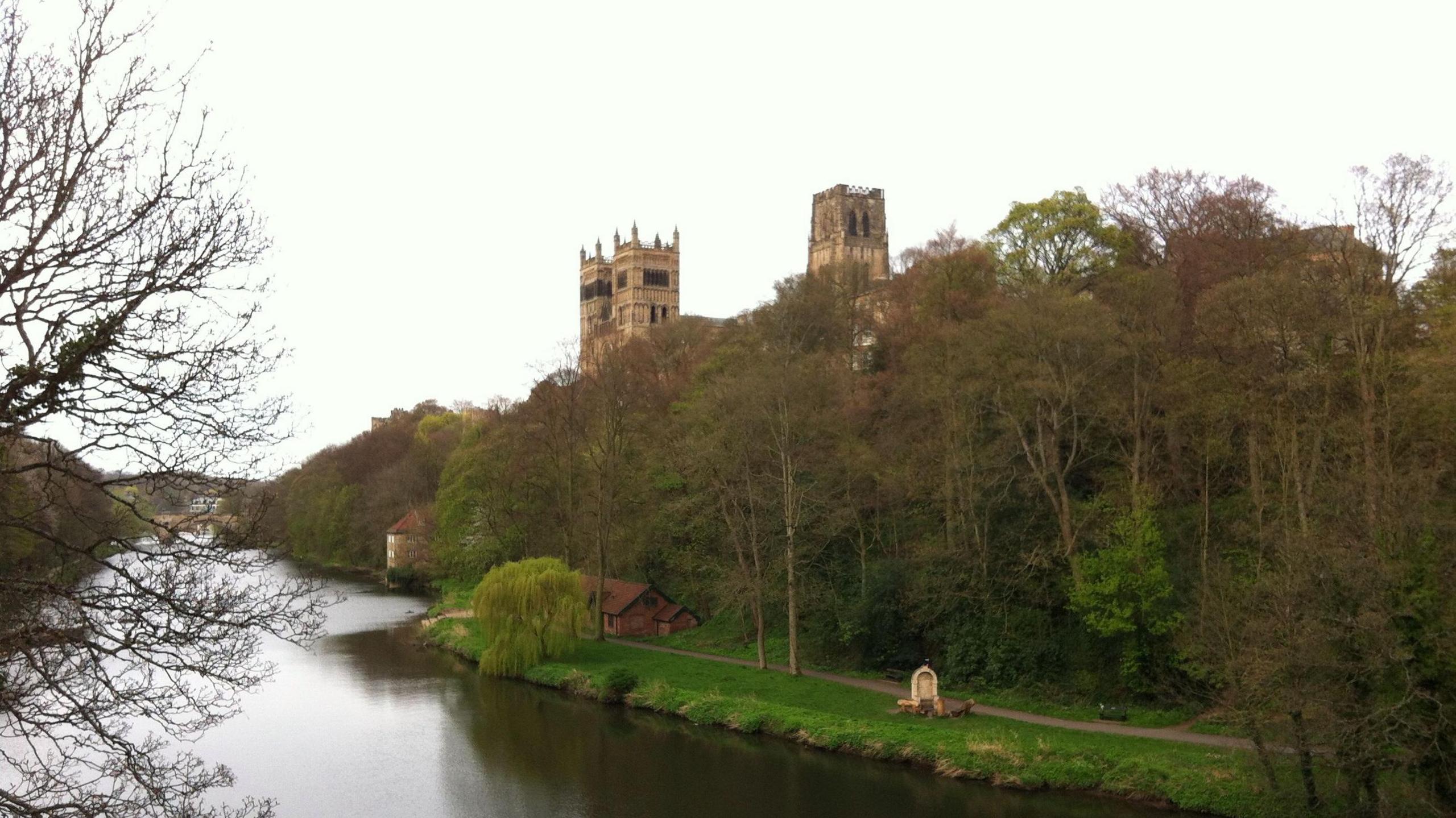 Durham Cathedral poking out of trees on a riverbank